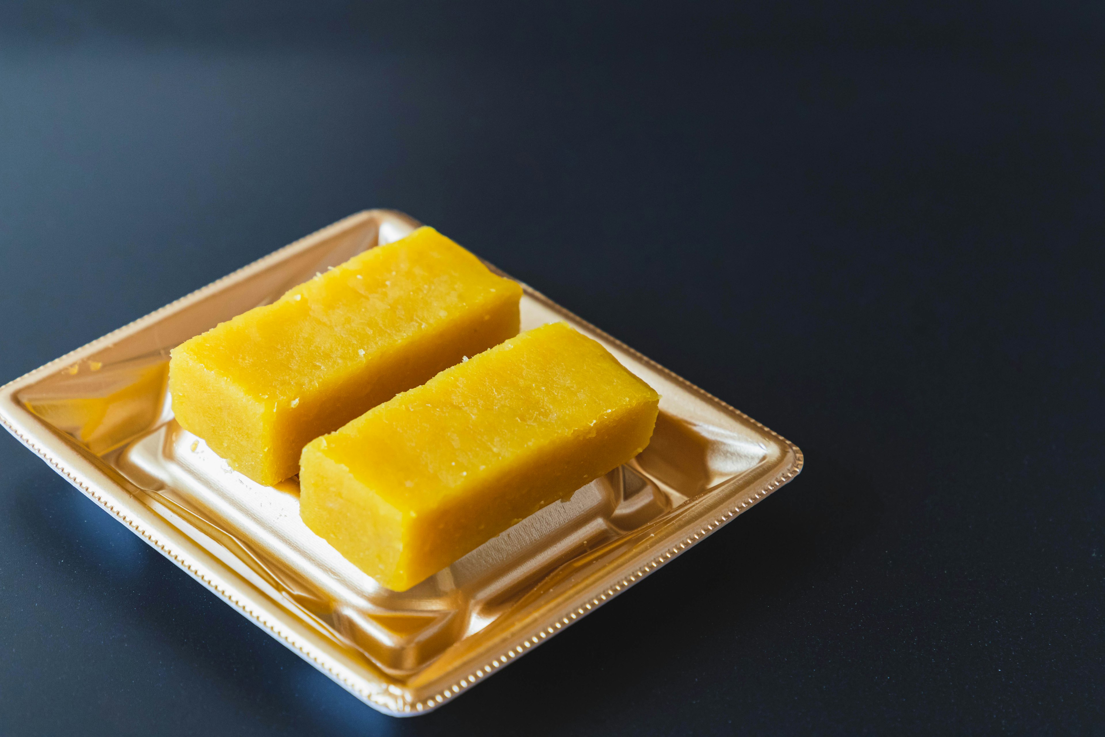 Two yellow desserts on a white plate