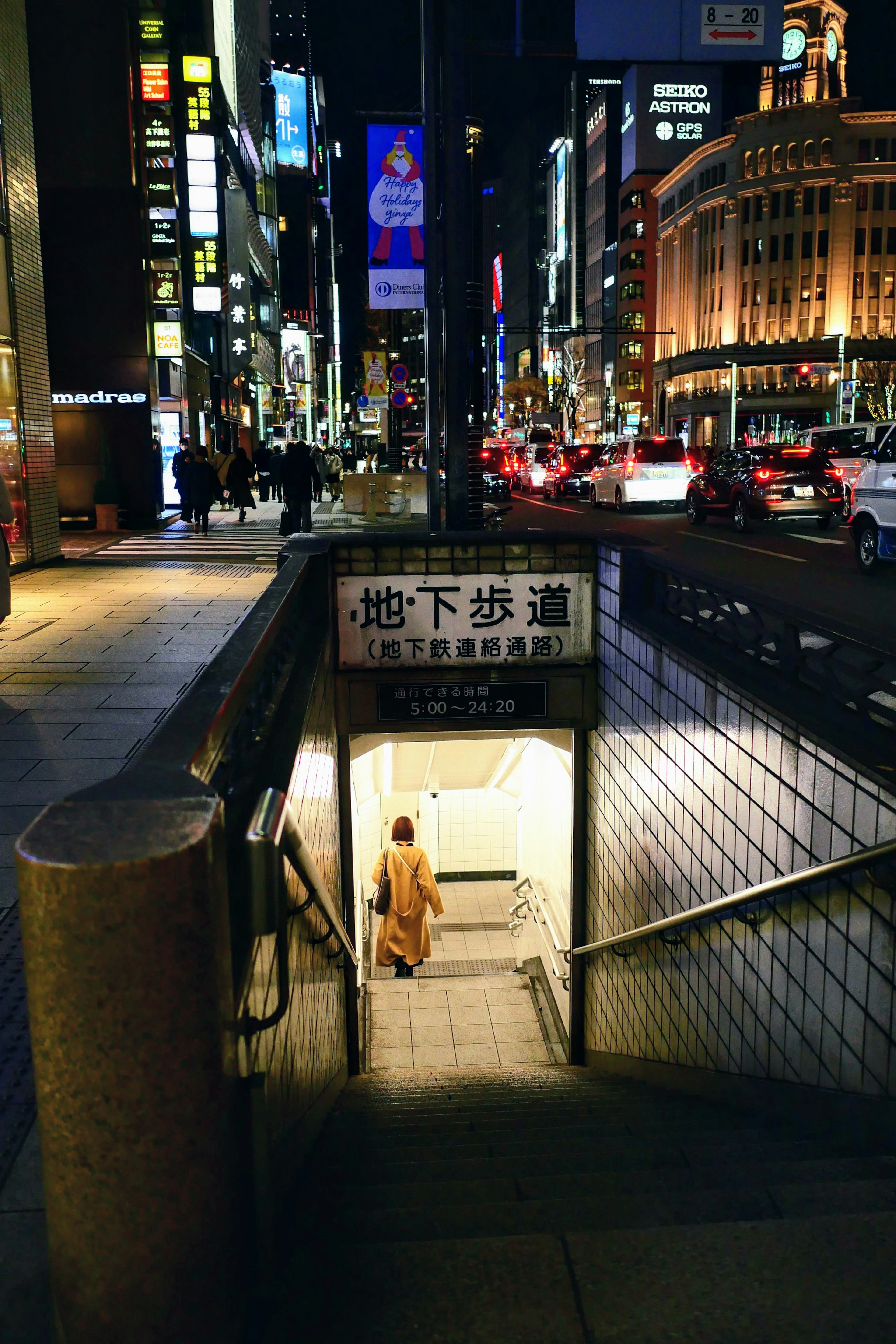 Scène montrant une entrée de métro dans une ville animée la nuit