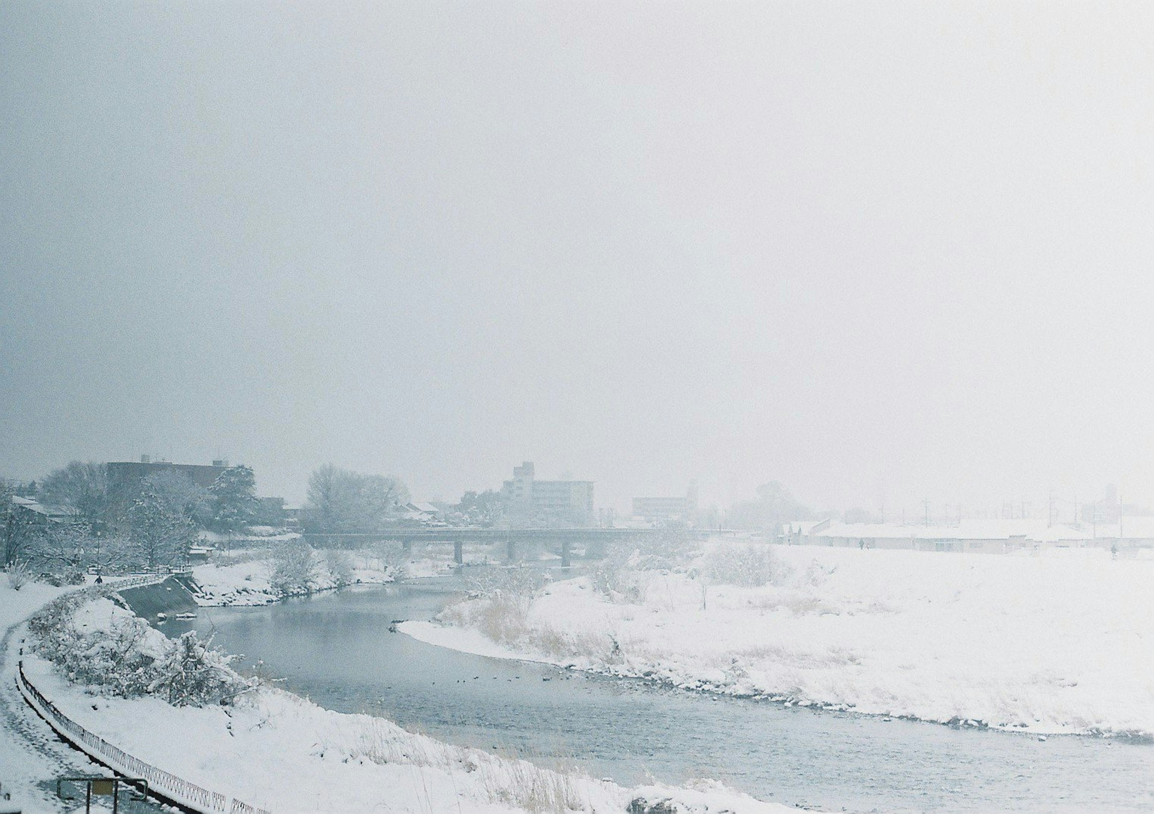 Schneebedeckte Fluss- und Stadtlandschaft