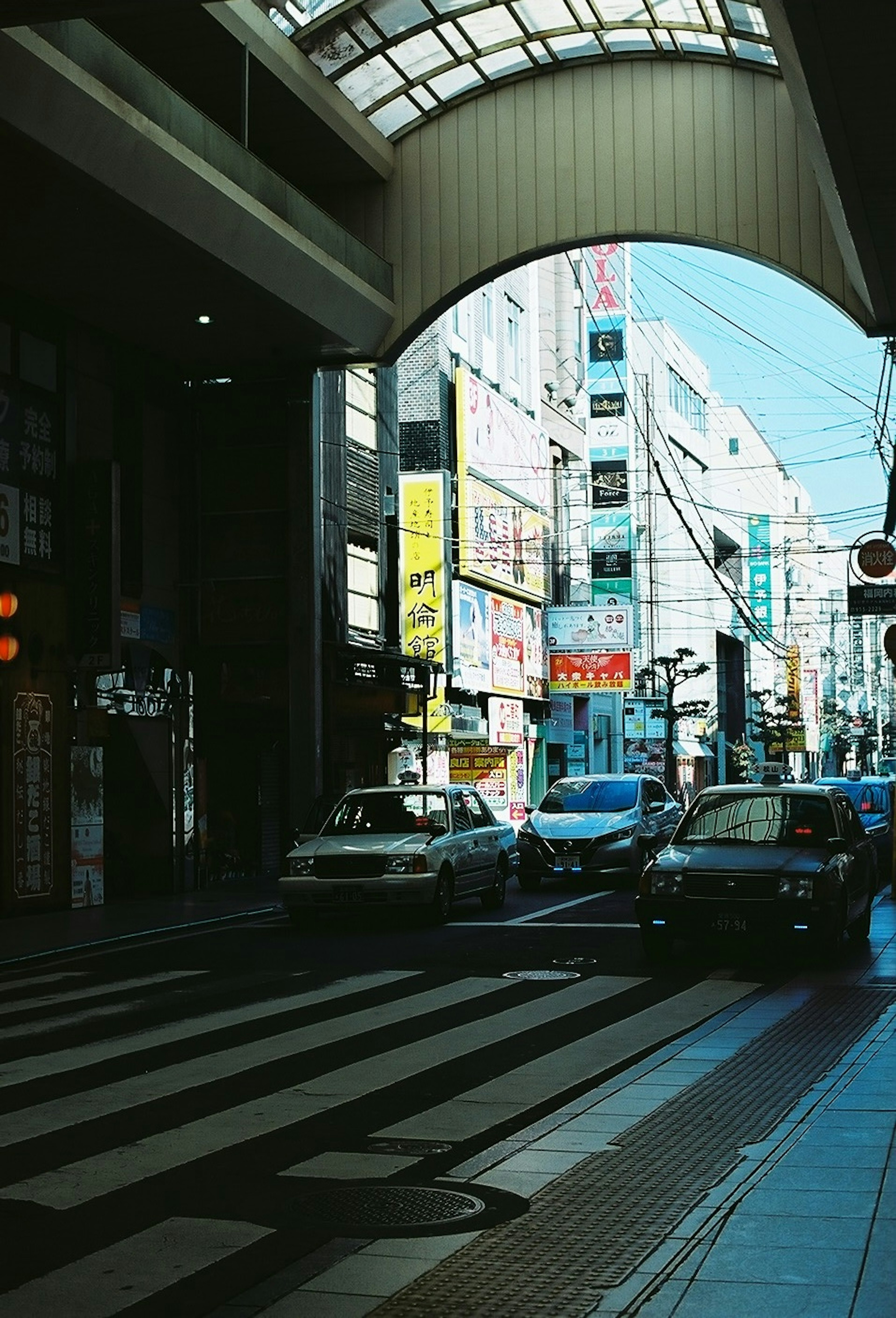 Vista de coches en un paso peatonal con edificios comerciales