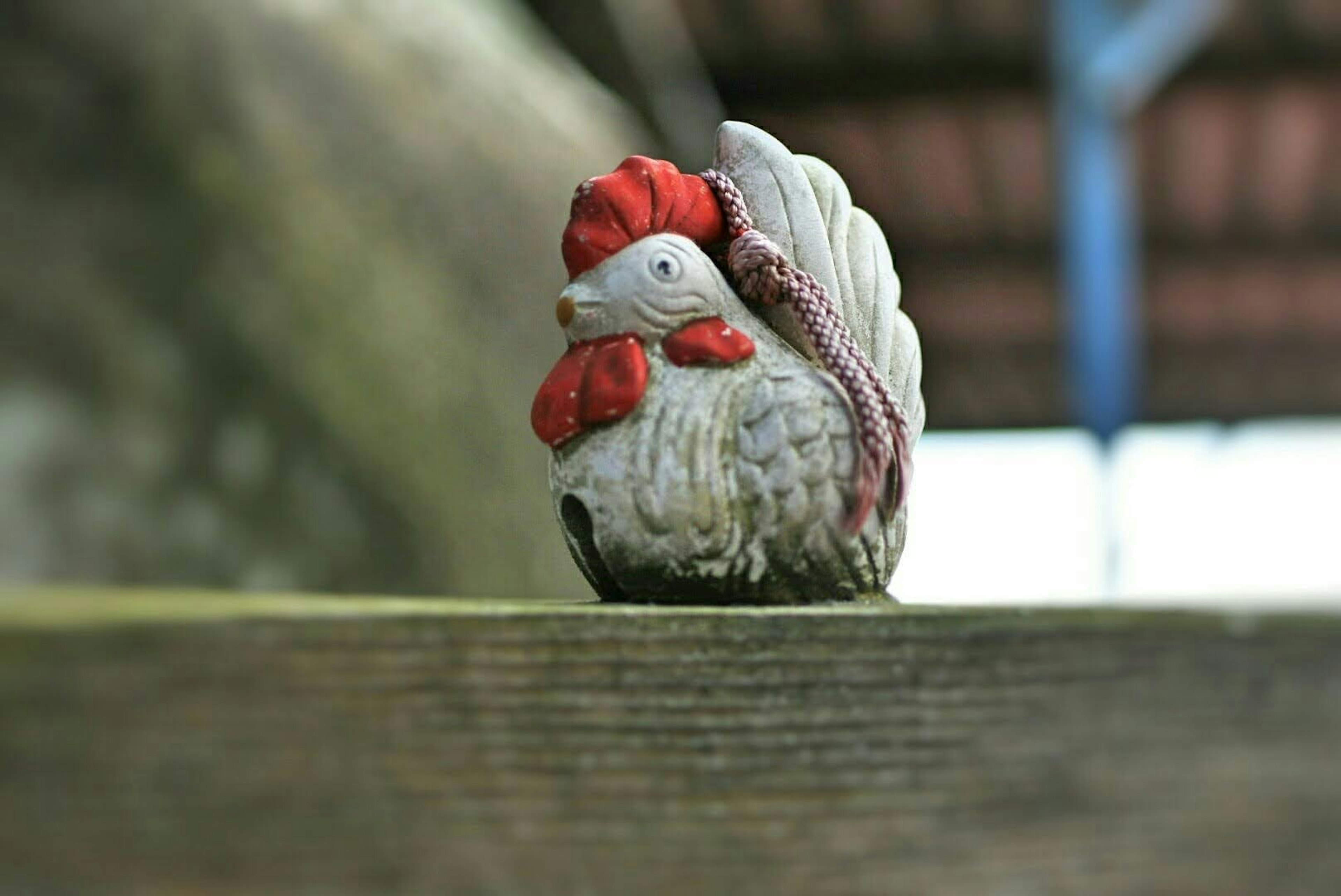 Una pequeña figura de gallo sobre una superficie de madera