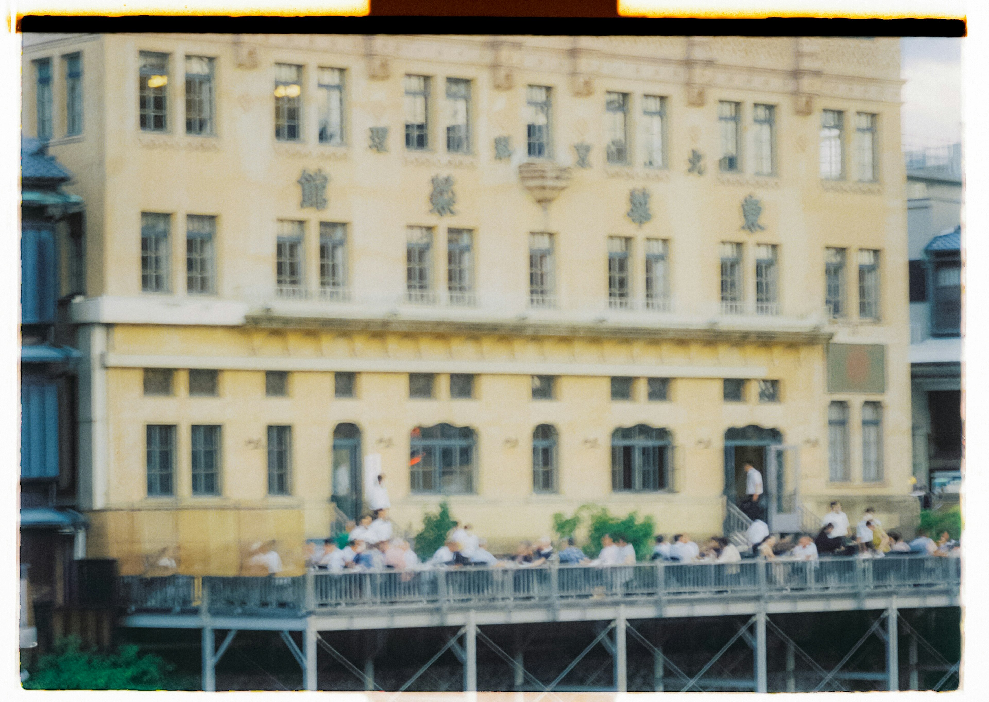 People gathering on a terrace of a yellow building