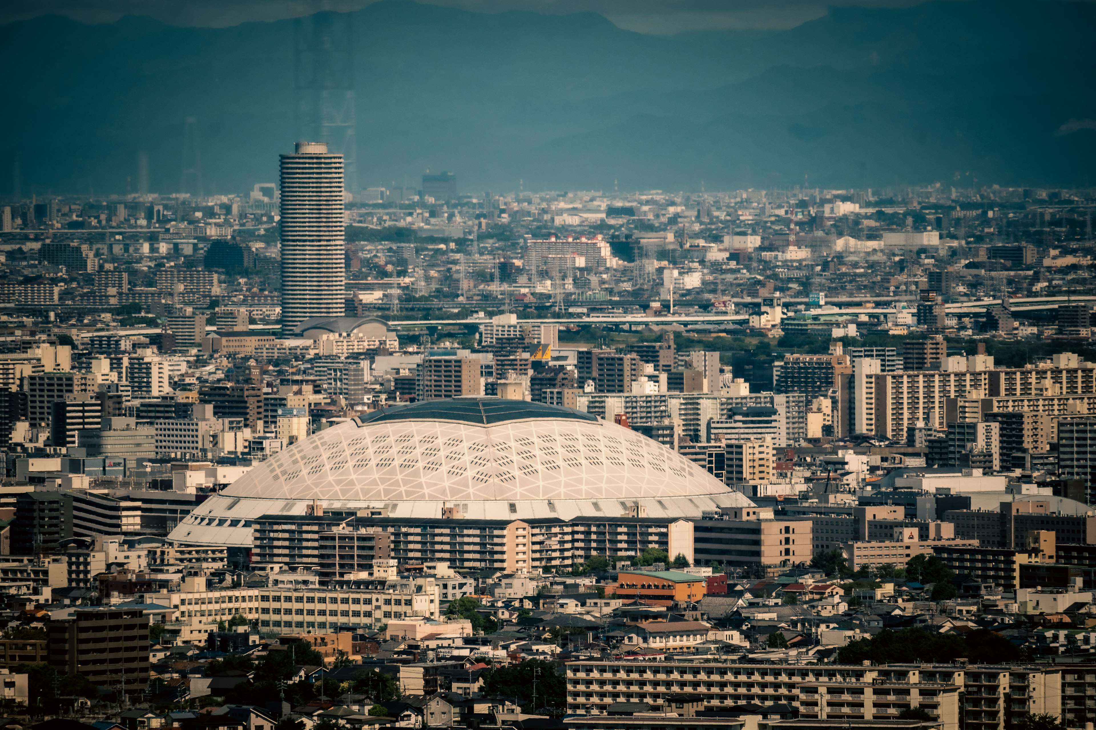 都市の風景にある大きなドーム型のスタジアムと高層ビル