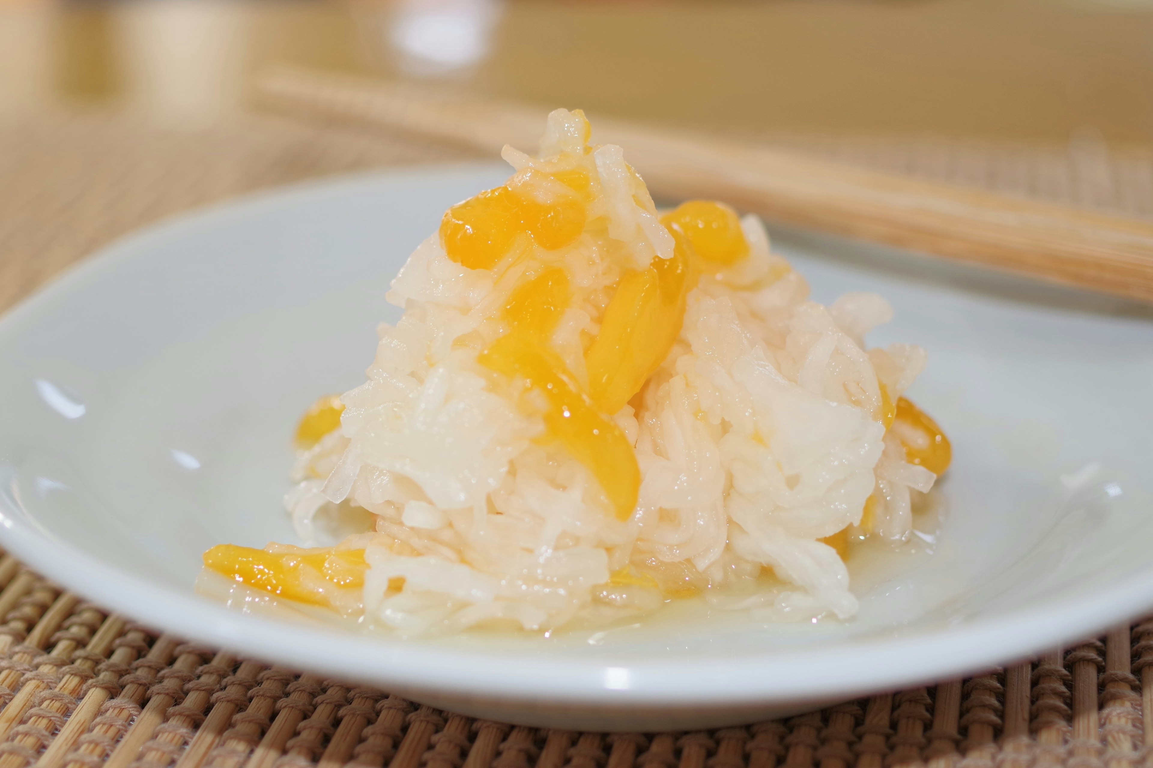 Un postre blanco cubierto con trozos de naranja en un plato