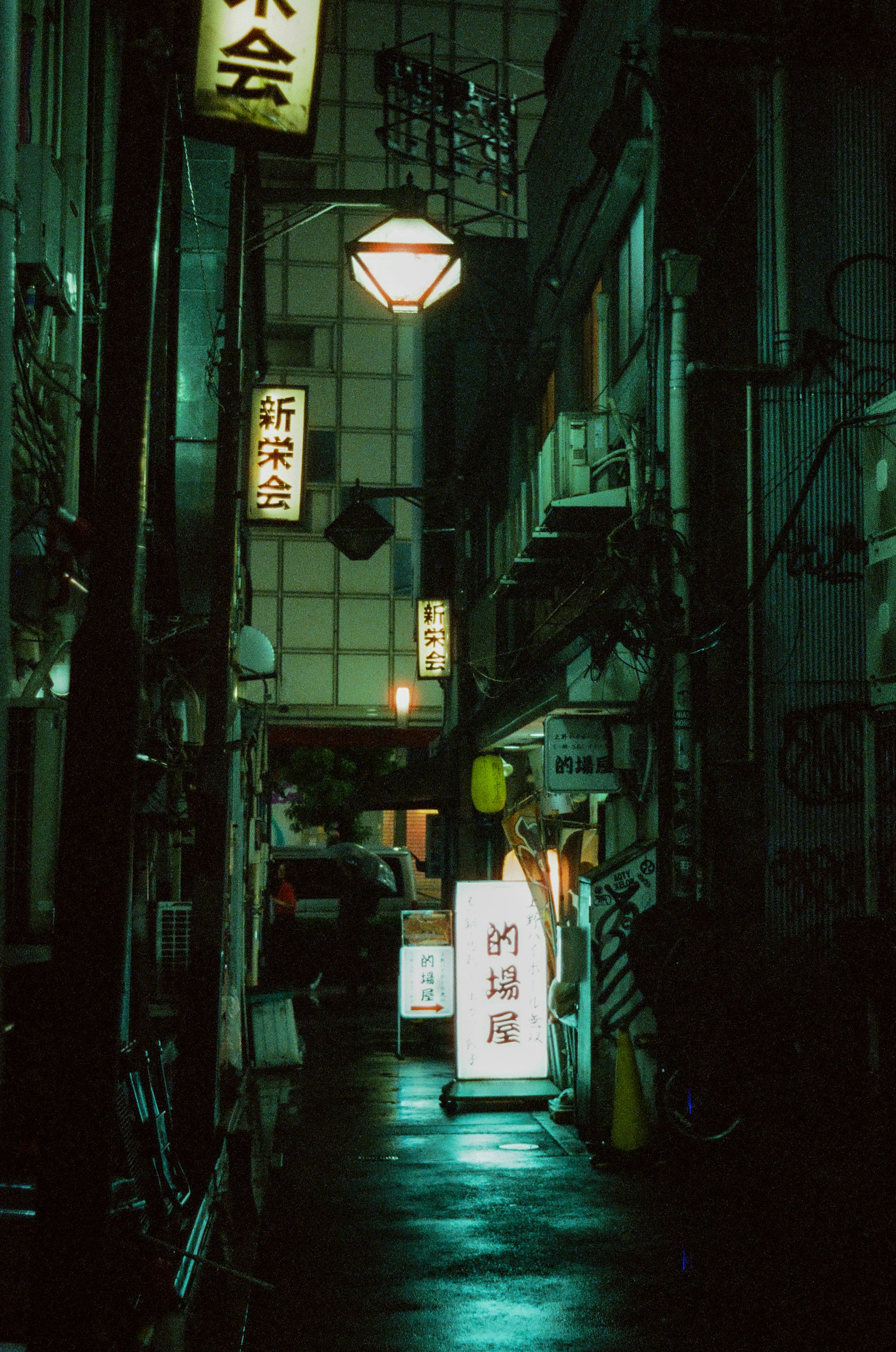 薄暗い路地に並ぶ看板と明かりのある街の風景