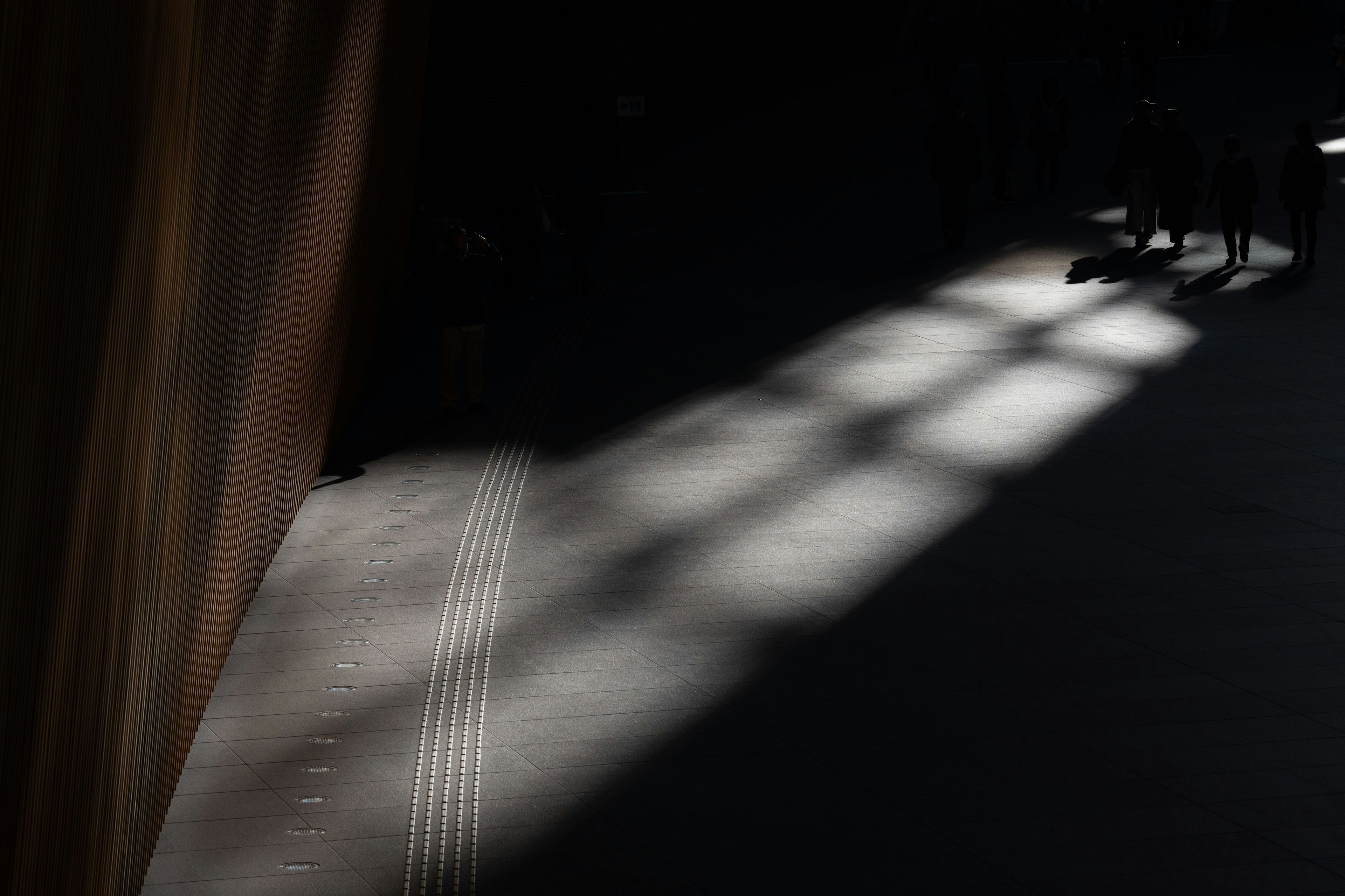 Contrasto tra fasci di luce e ombre in uno spazio scuro