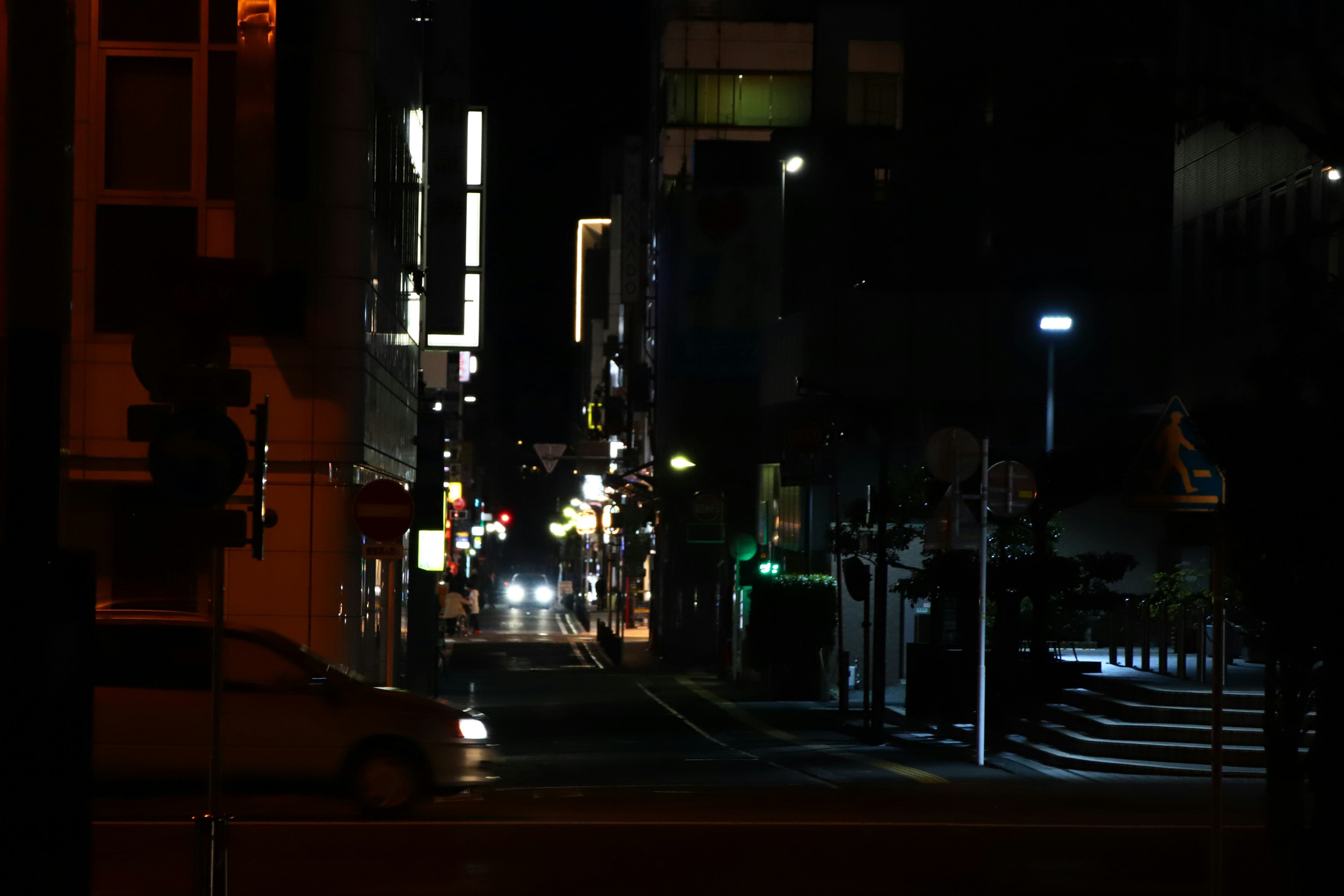 Paesaggio urbano notturno con luci delle auto e lampioni