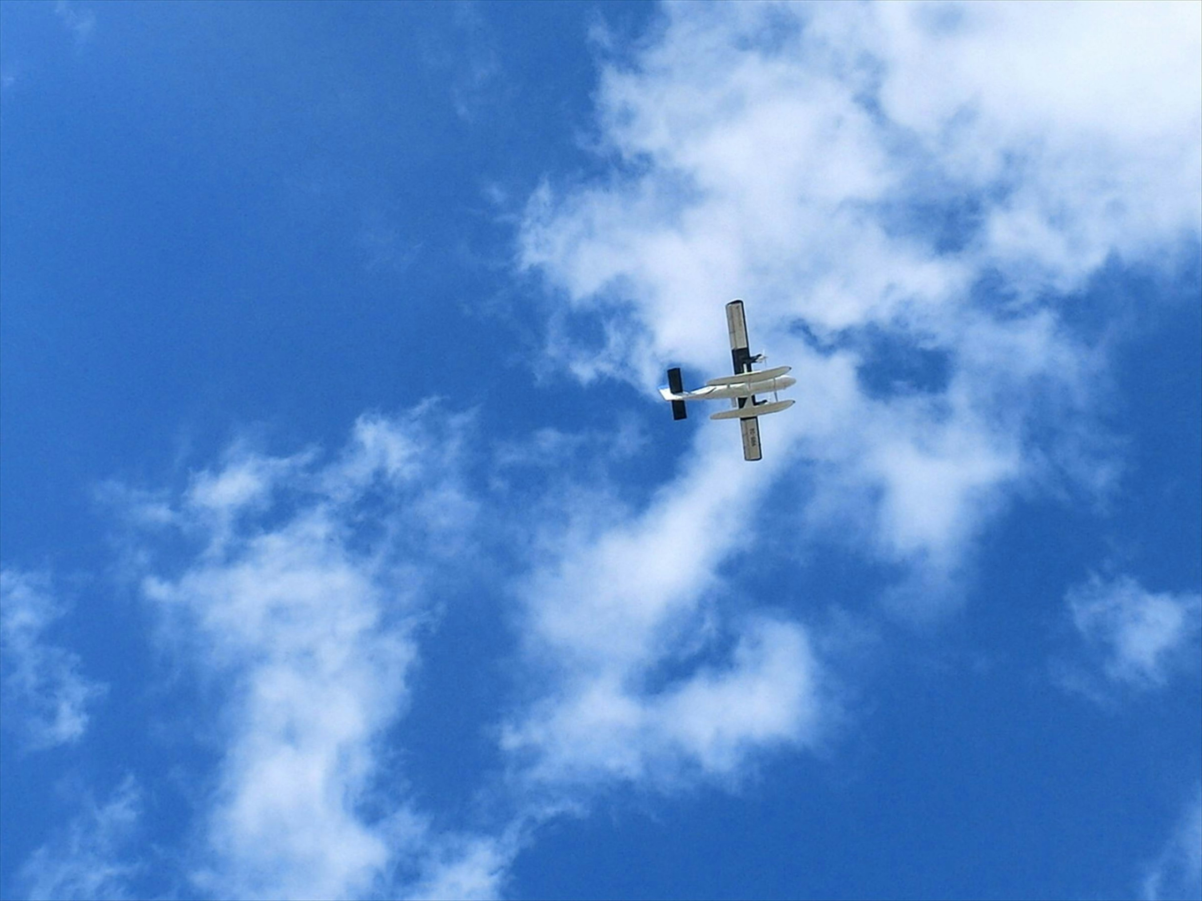 藍天白雲中飛行的小型飛機