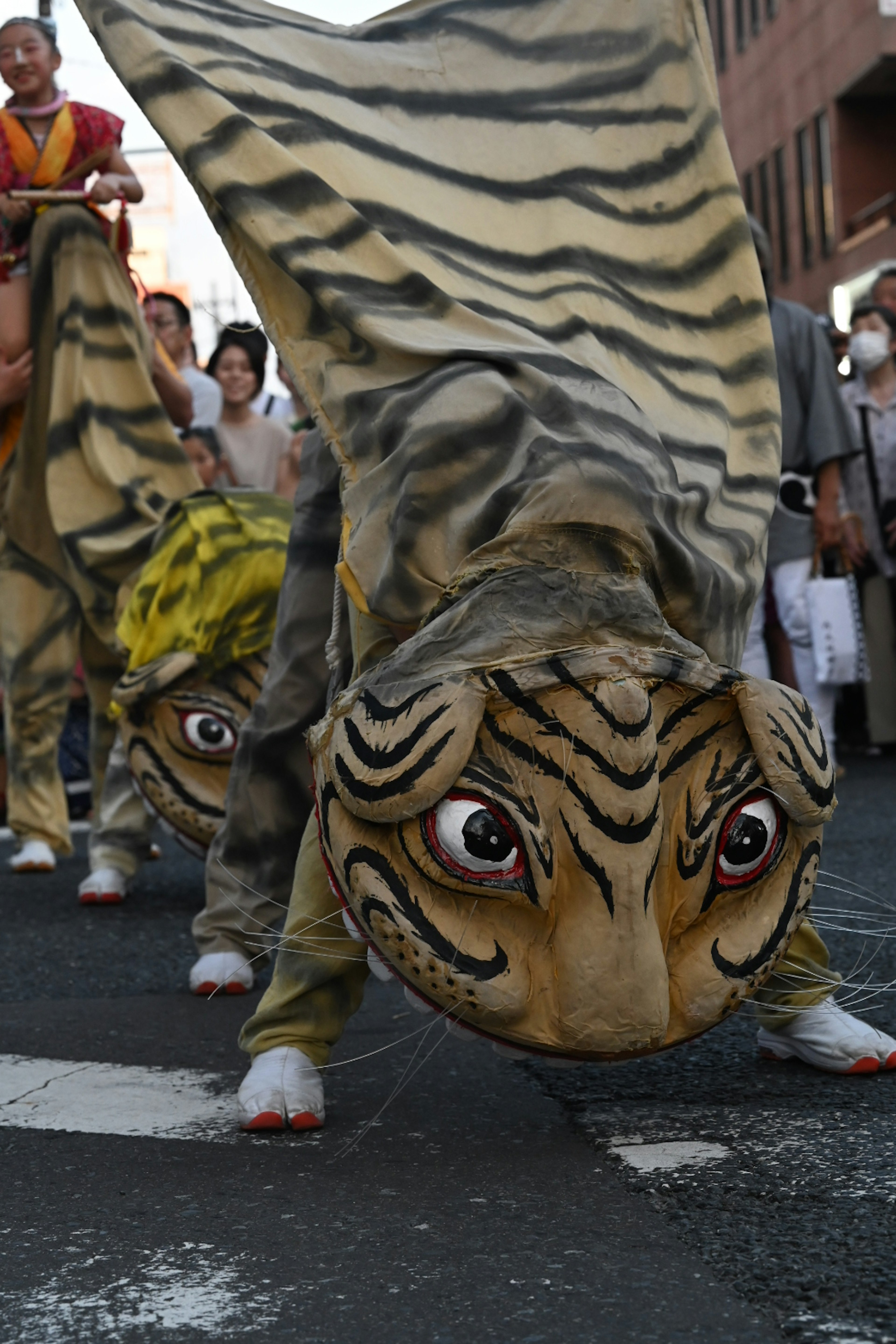 Festivalszene mit Menschen in tigerbedruckten Kostümen, die marschieren