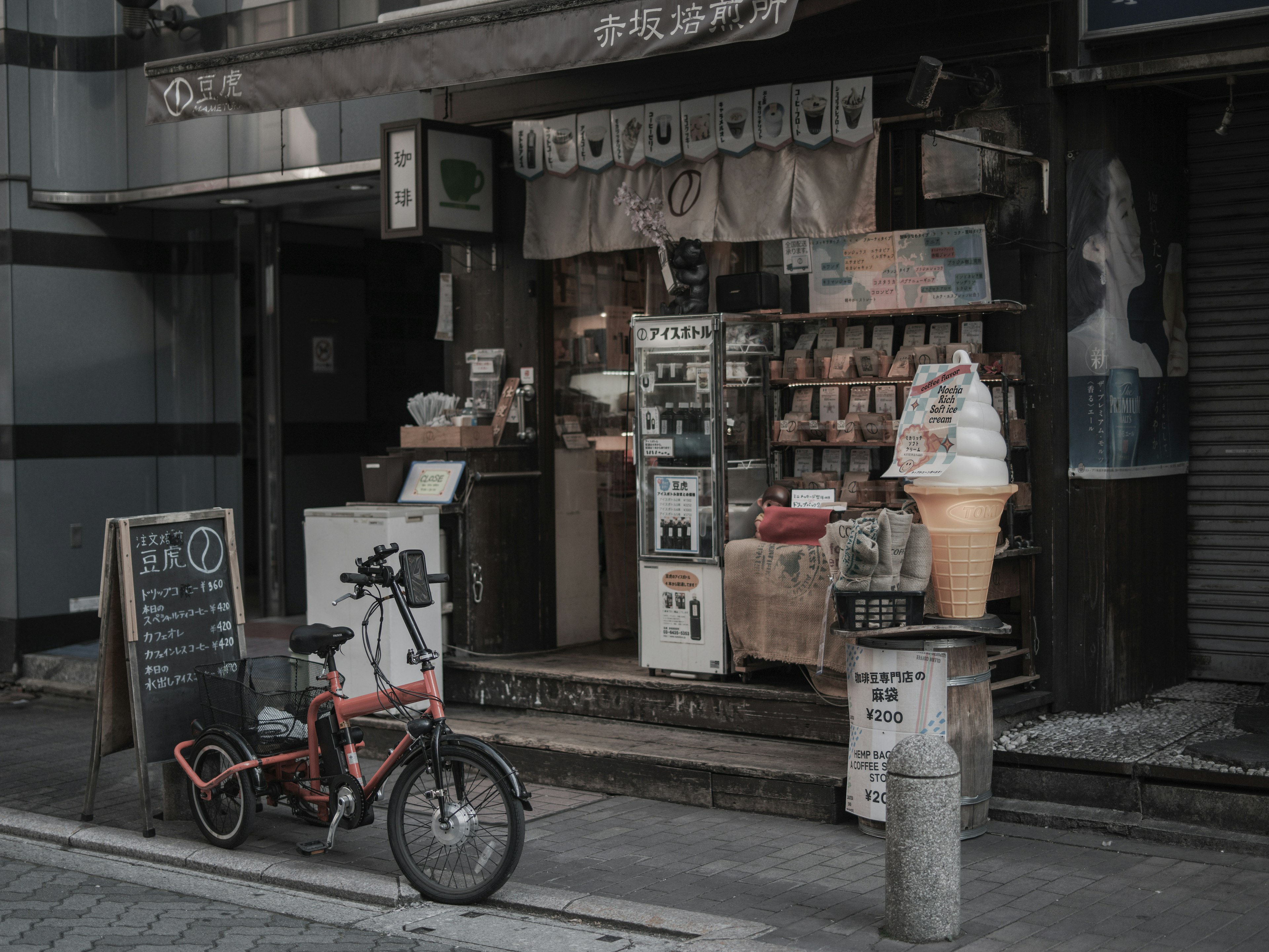 Una piccola vetrina di negozio con una bicicletta parcheggiata all'esterno che mostra vari prodotti