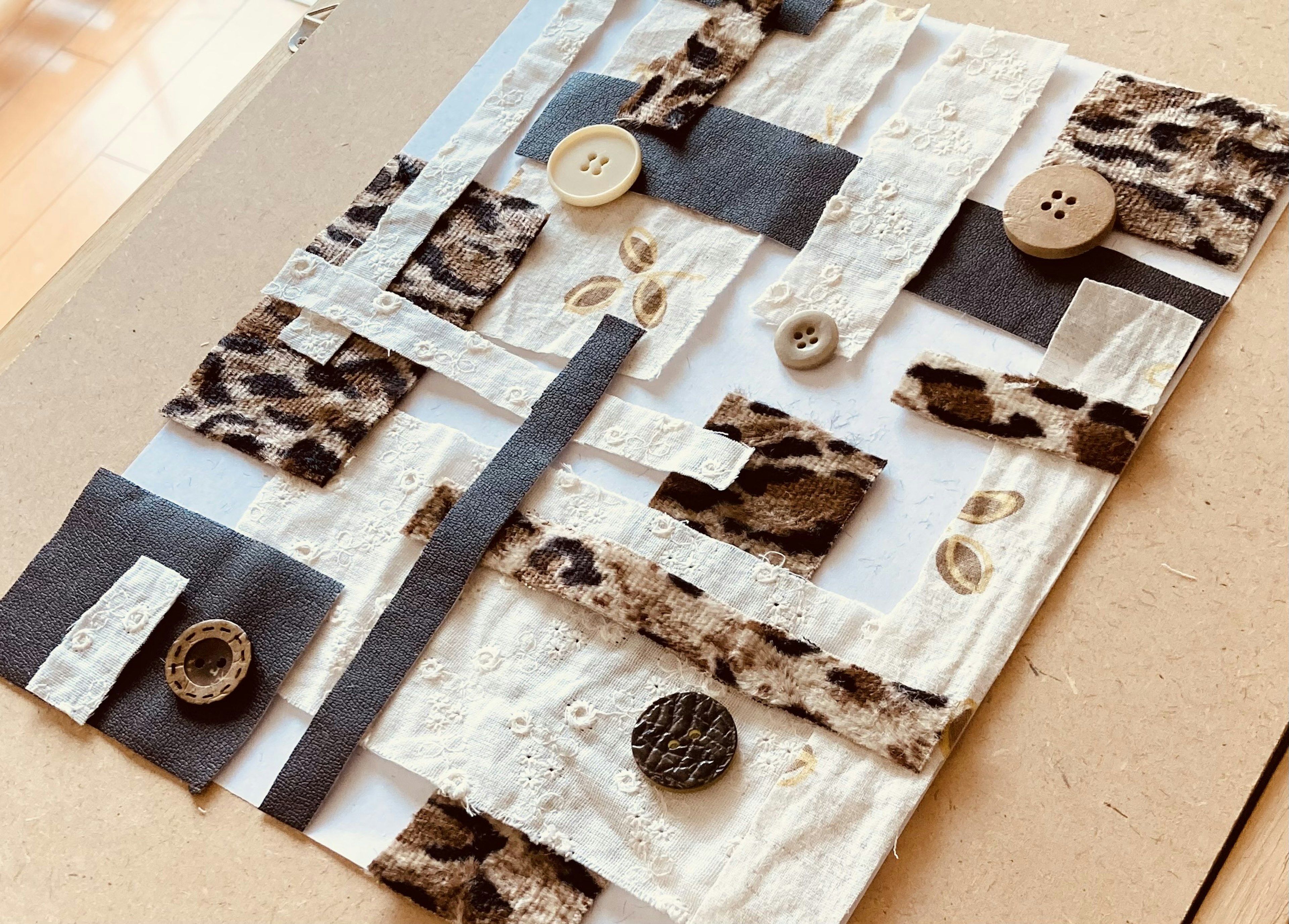 Art piece featuring a collage of various textures including buttons and wood