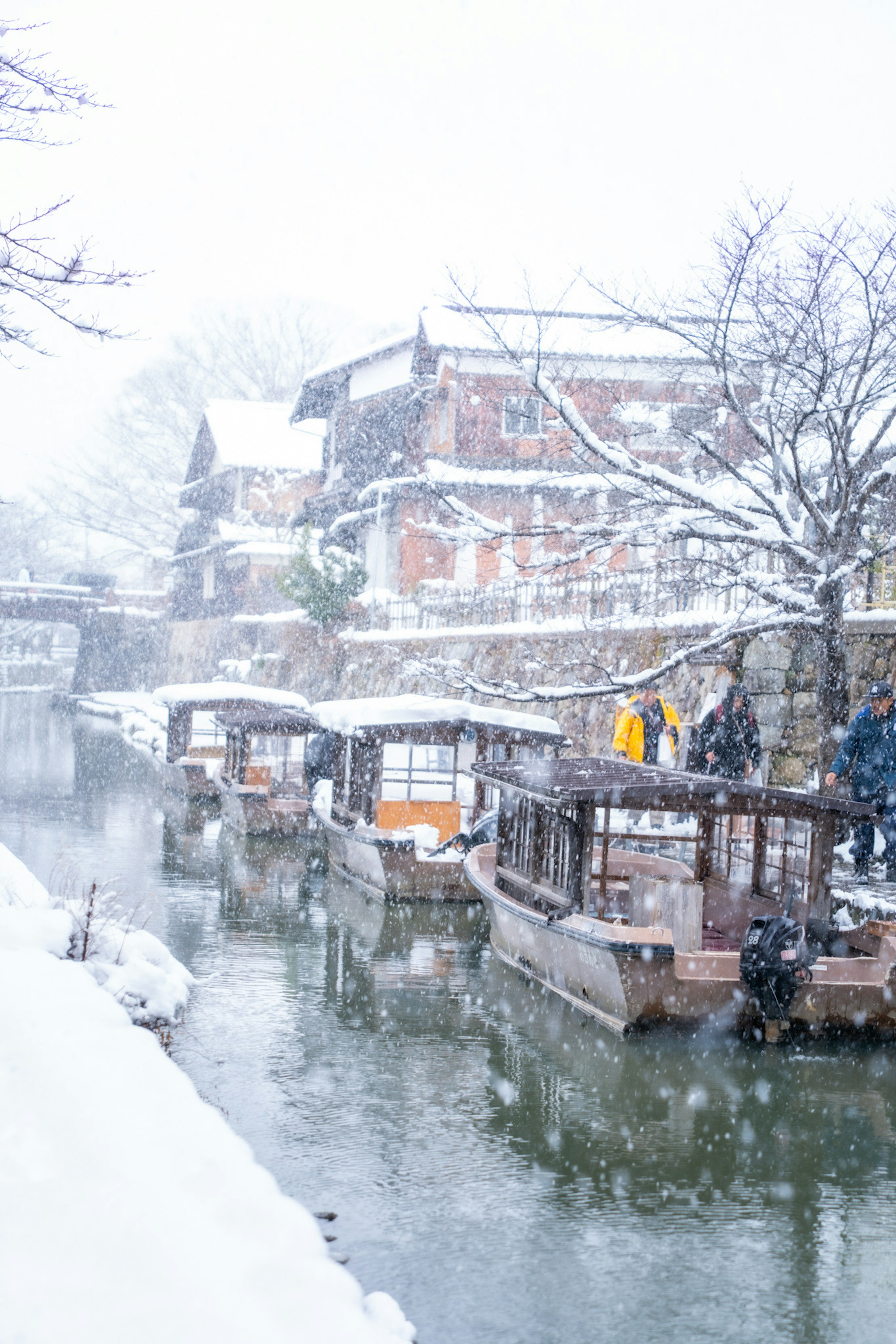 Snow-covered canal with traditional boats lined up