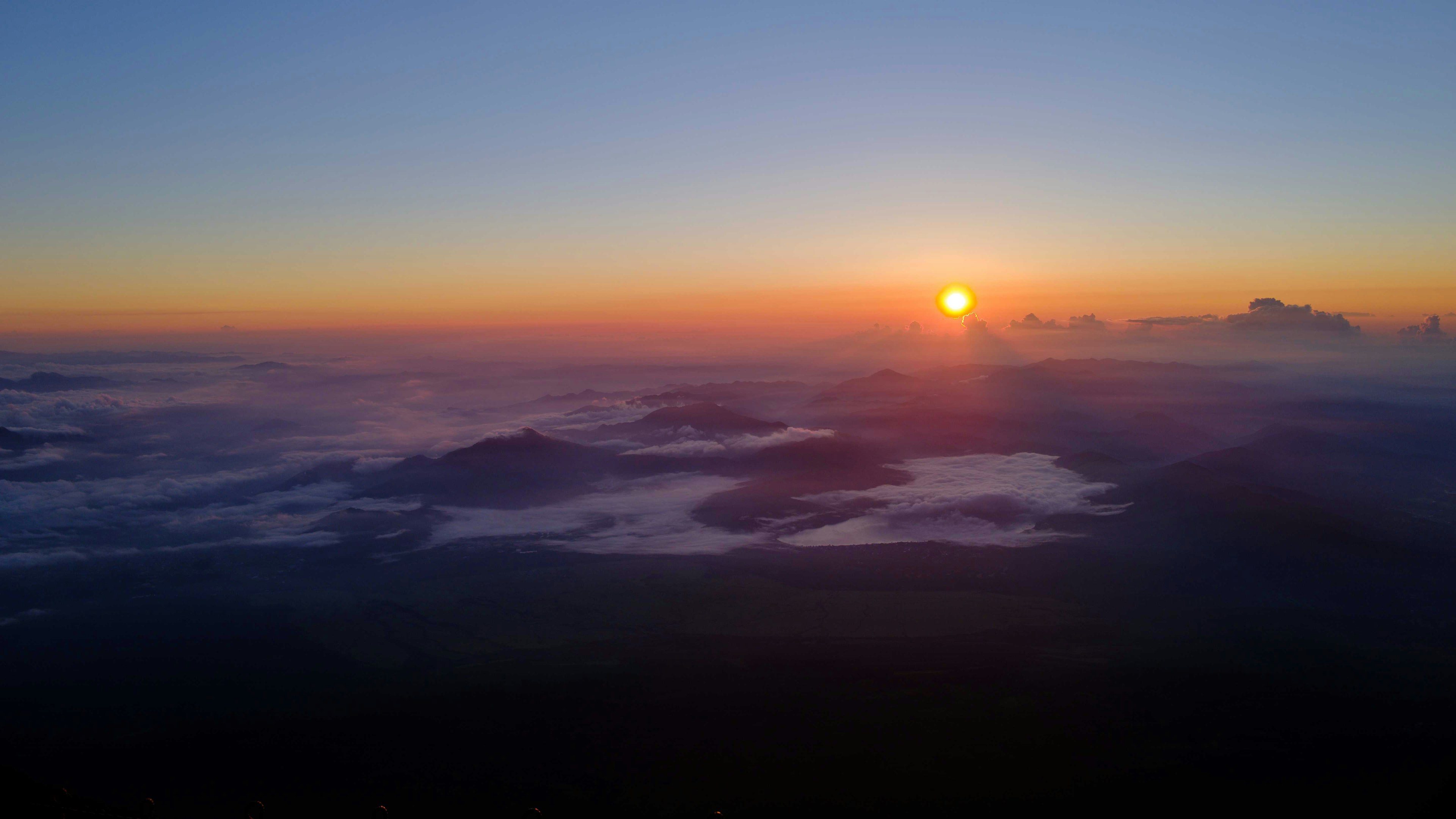 Wunderschöner Sonnenuntergang über den Wolken mit Bergen in der Ferne