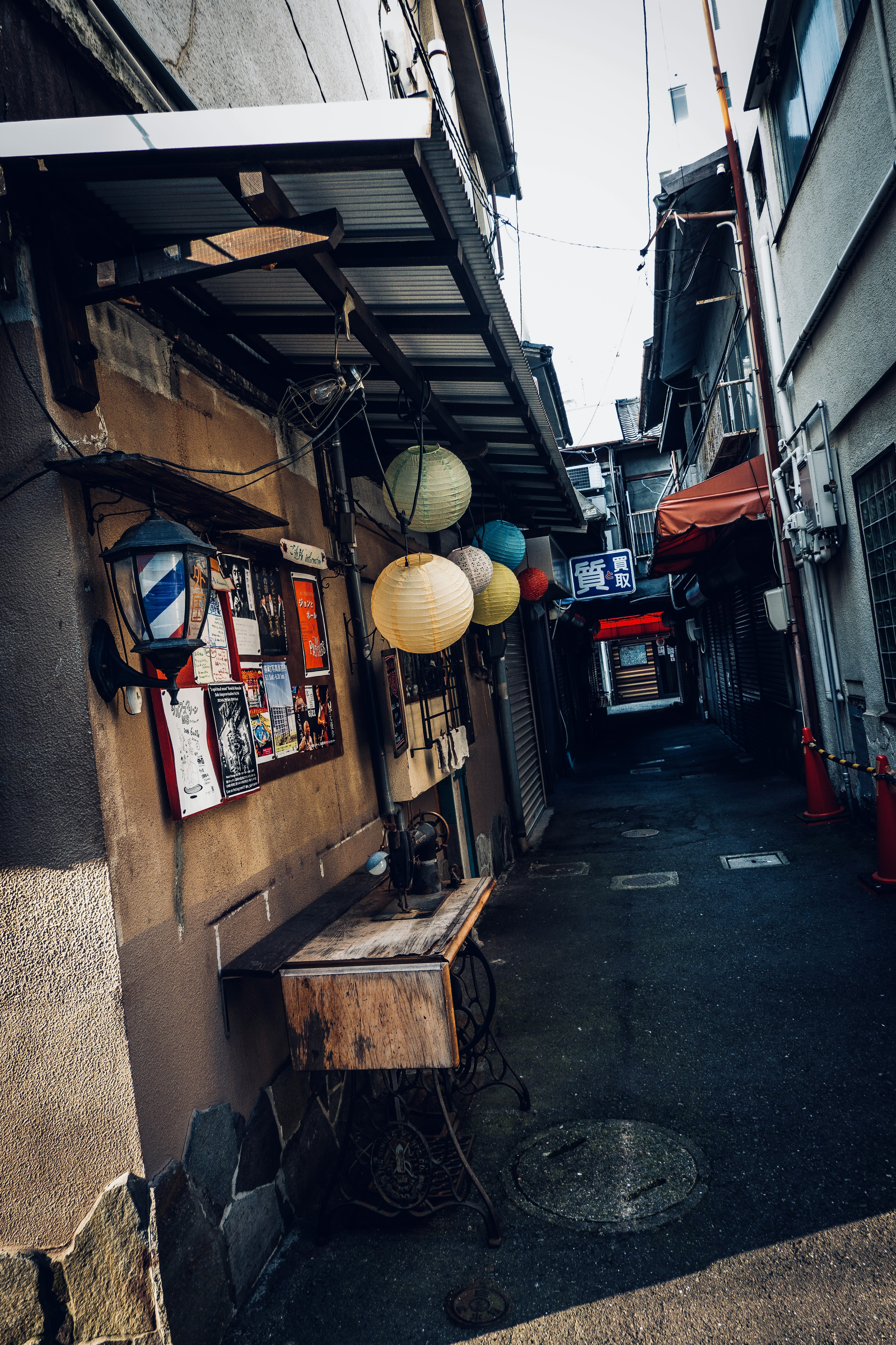 狭い路地にあるカラフルな提灯と木のテーブルの風景