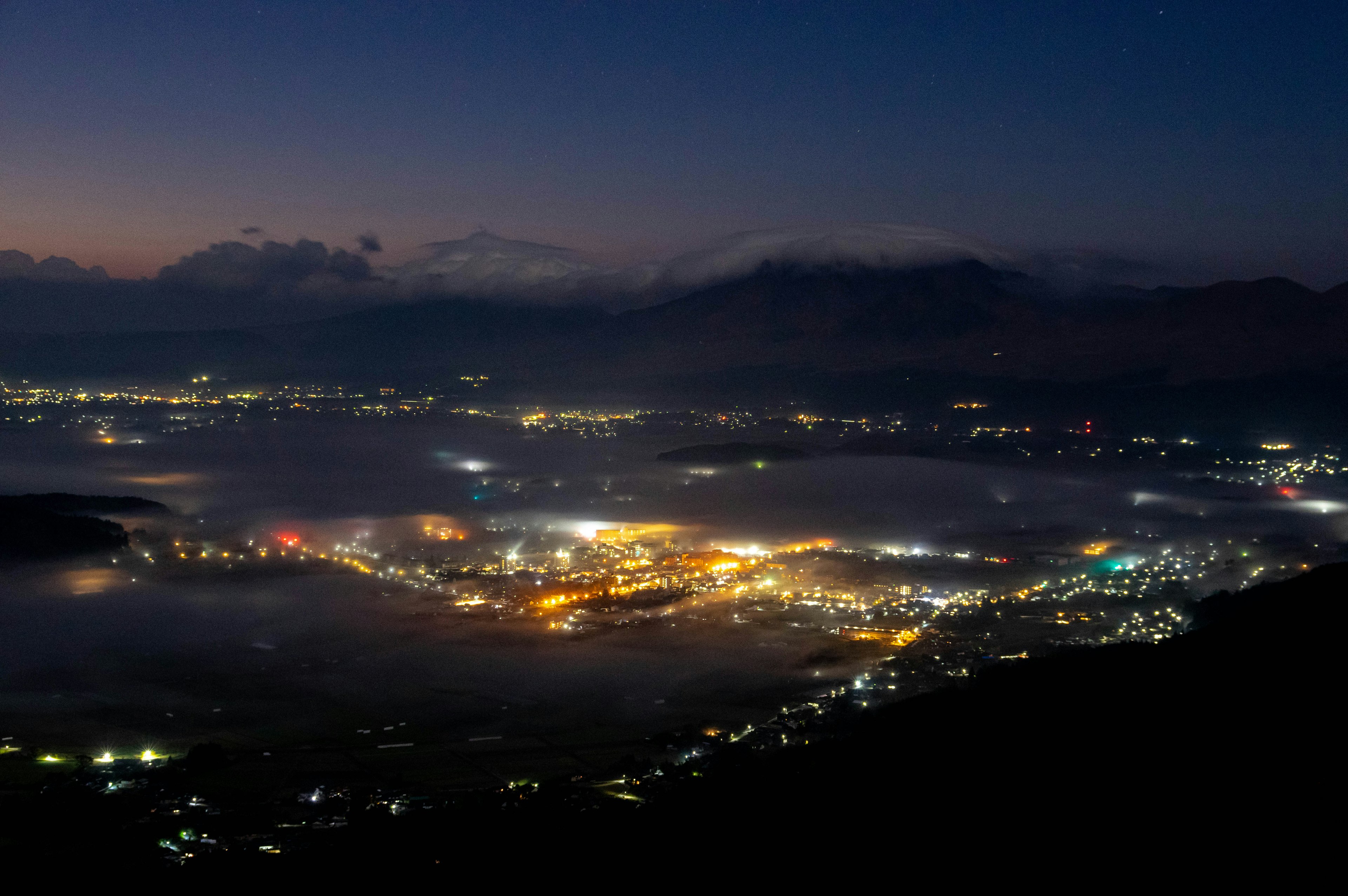 Night view of city lights and fog from a mountain