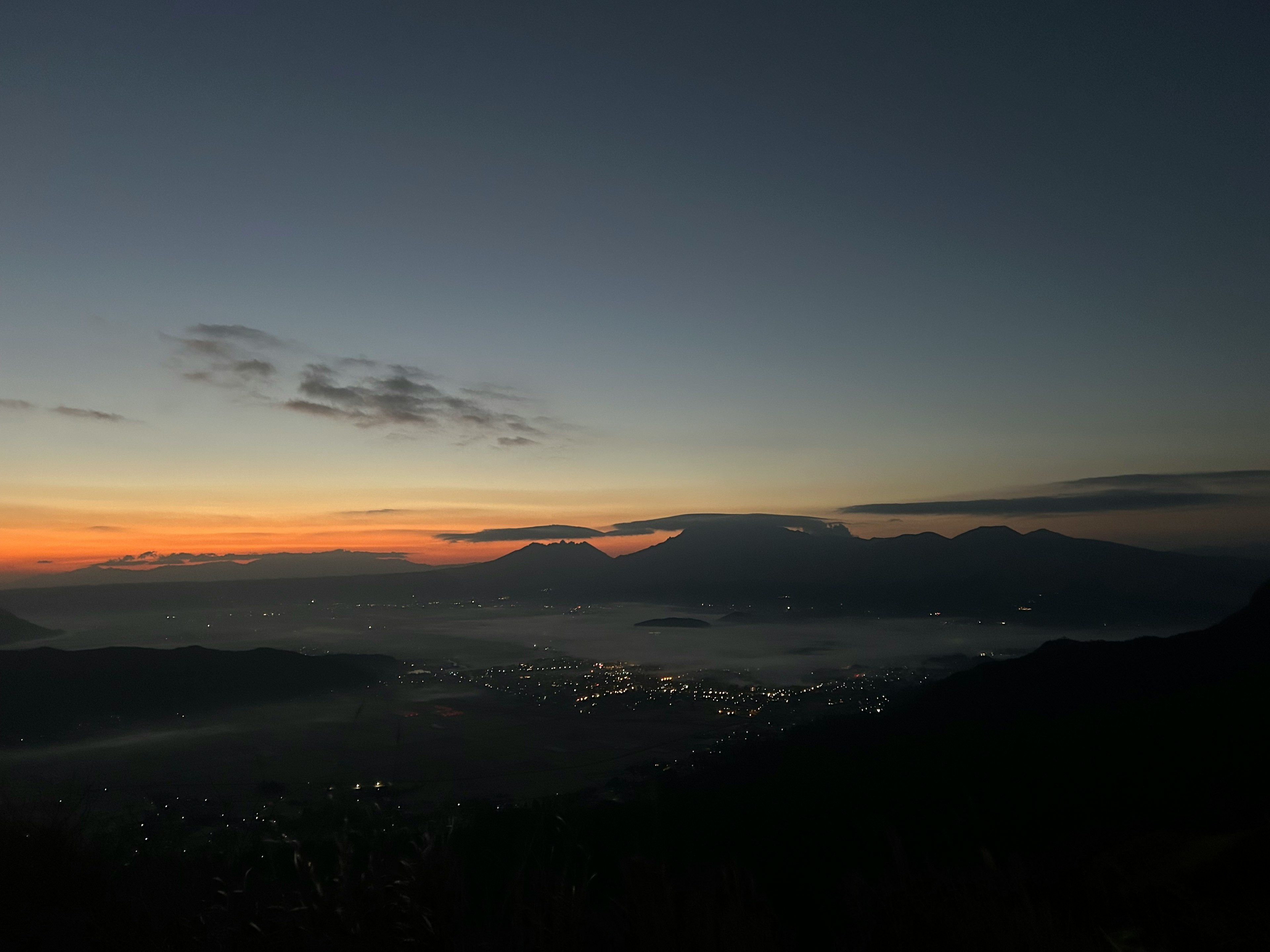 Scenic view of mountains and city lights before dawn