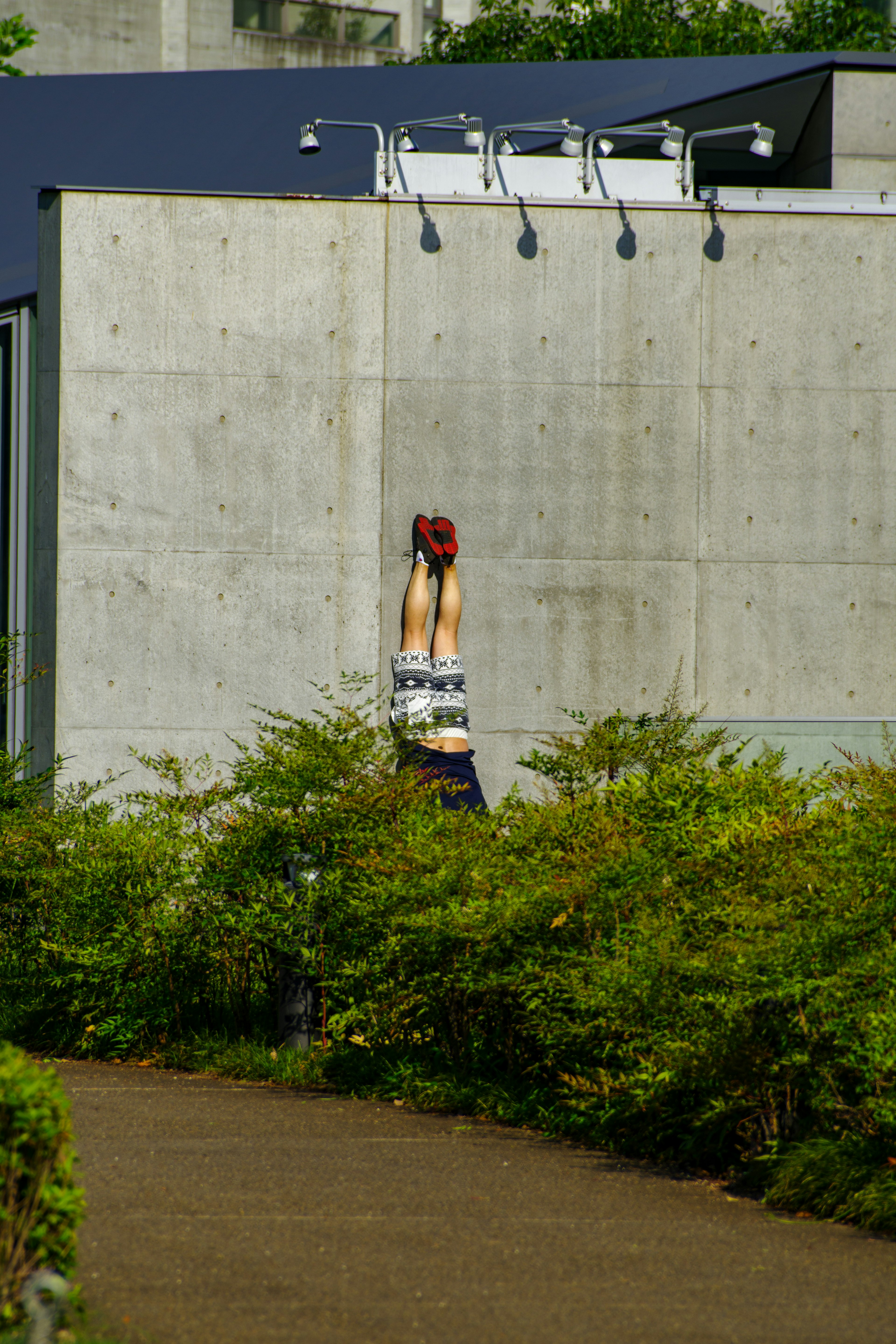 Eine Frau, die vor einer Betonwand einen Handstand macht