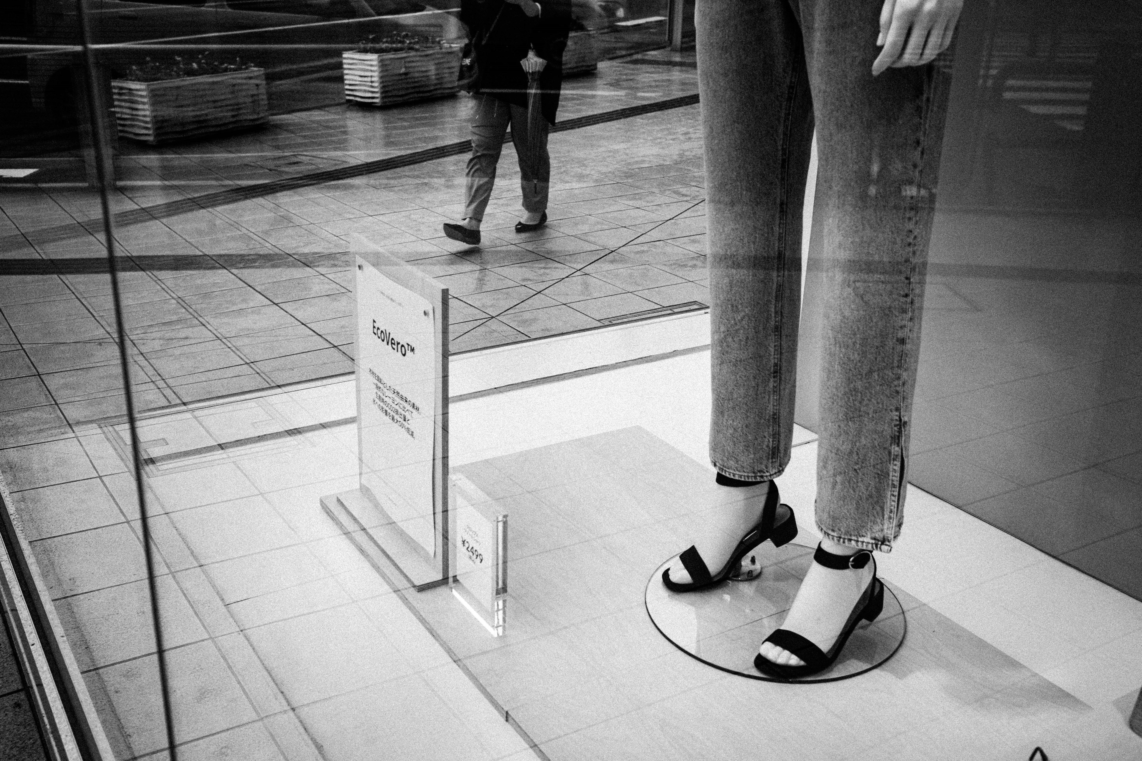 Close-up of jeans and sandals displayed in a shop window