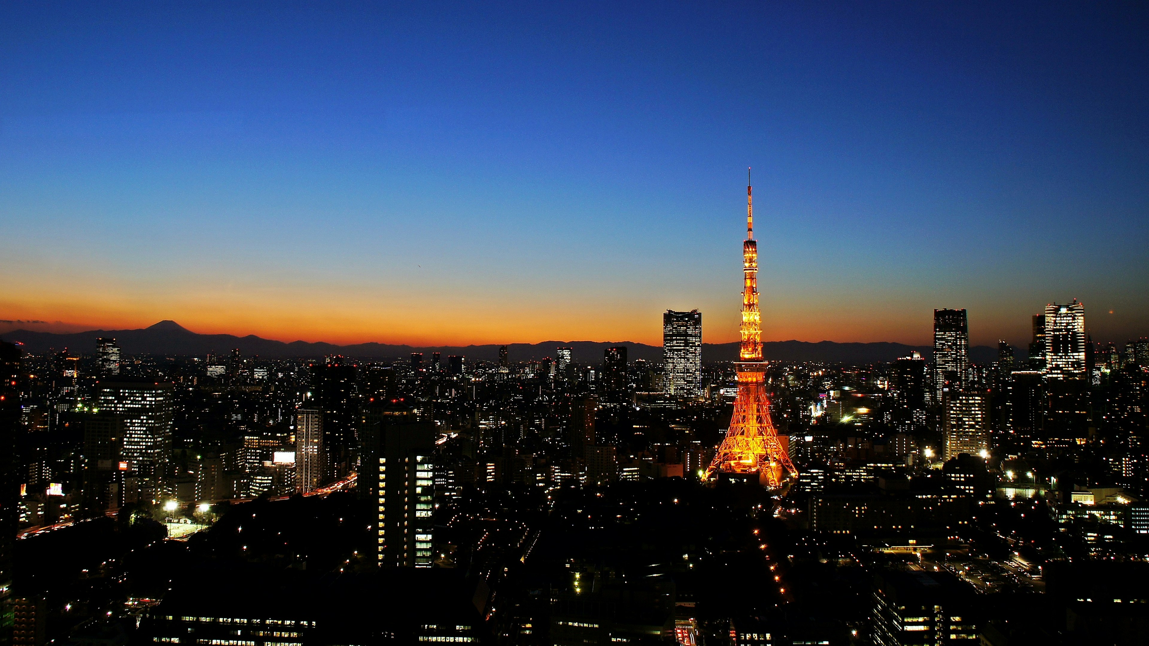 Tokyo Tower illuminated at dusk over the Tokyo skyline