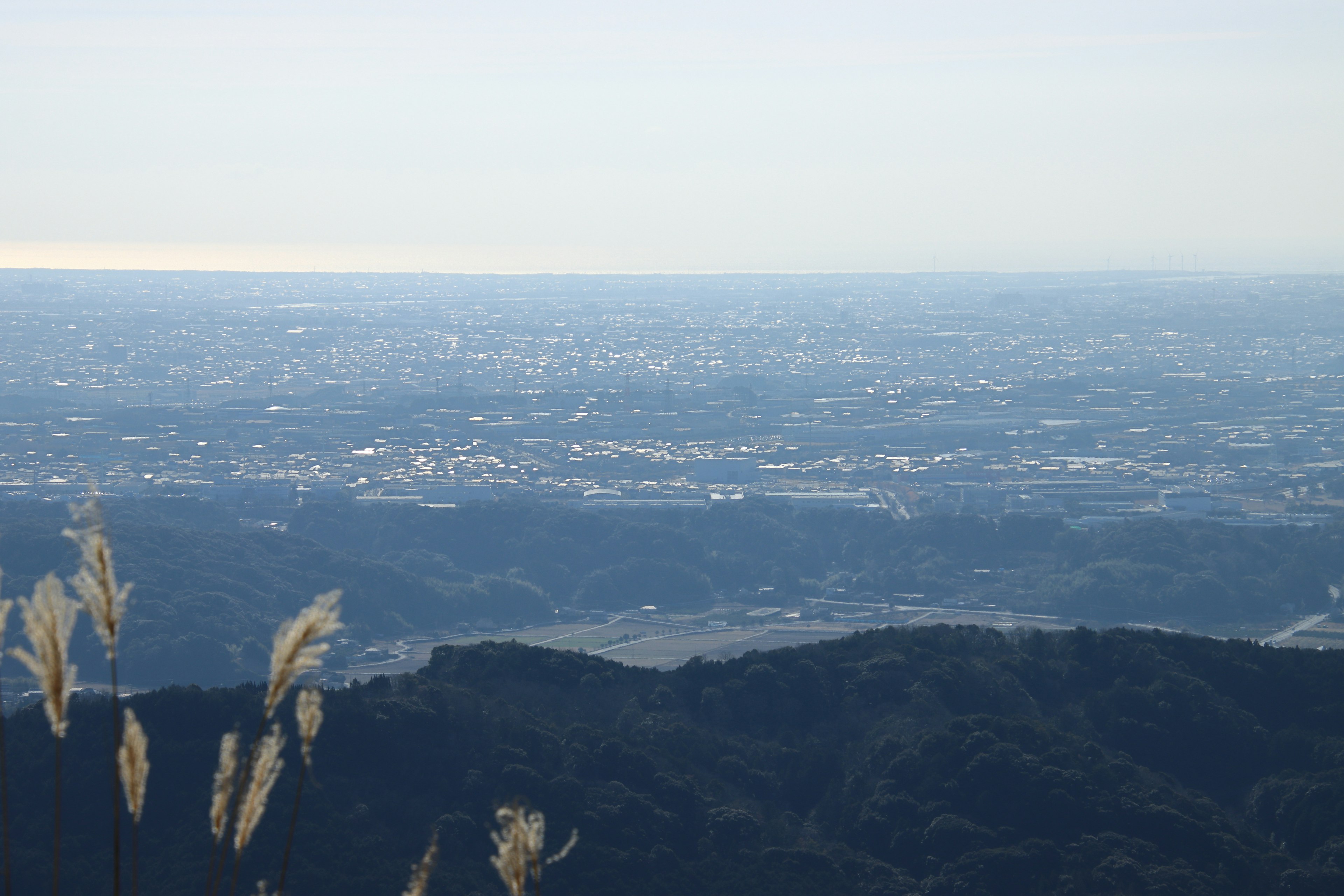 Aussicht von einem Berggipfel mit einer fernen Stadt und einer natürlichen Landschaft