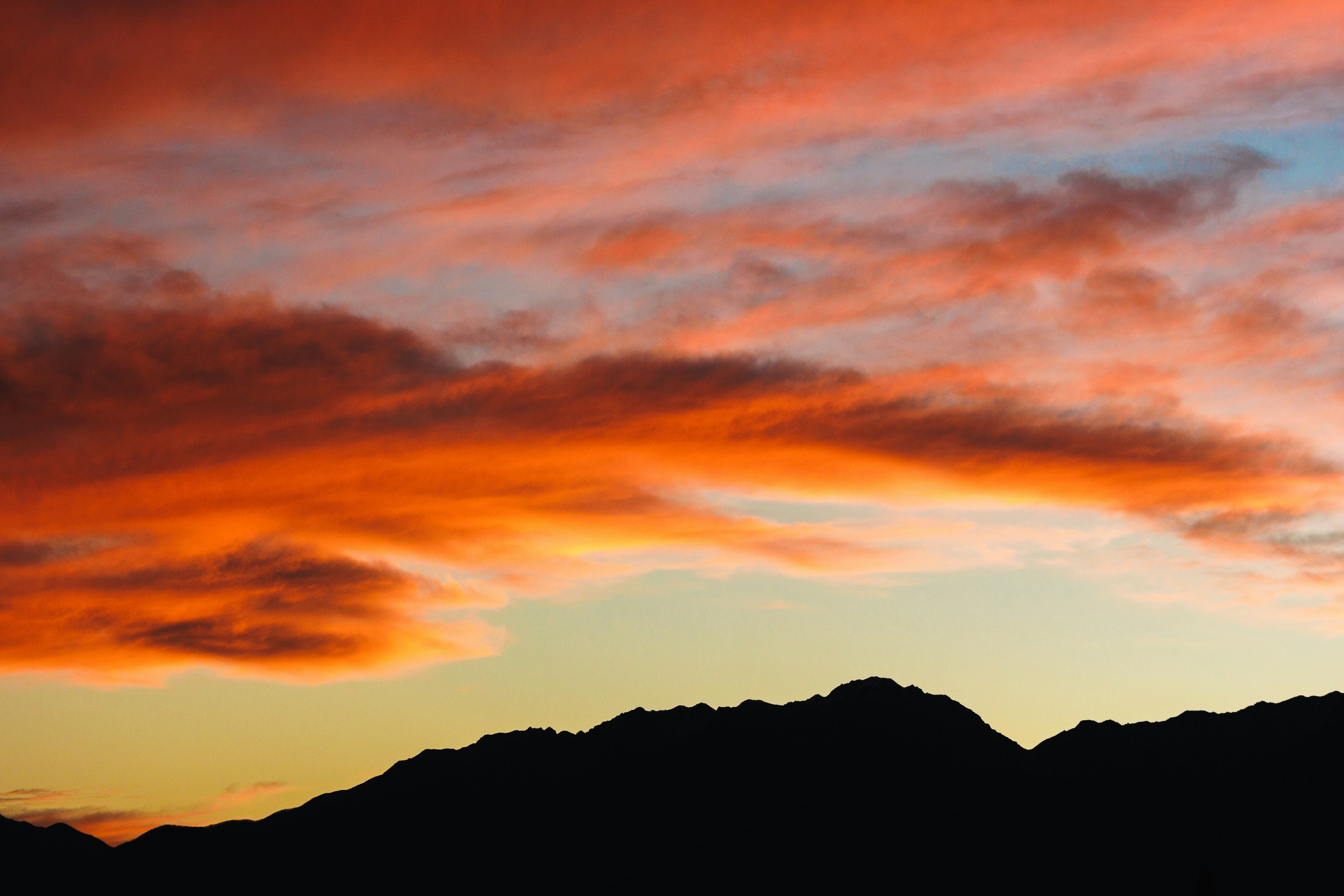 Silhouette von Bergen mit lebhaft orangefarbenem Sonnenuntergangshimmel