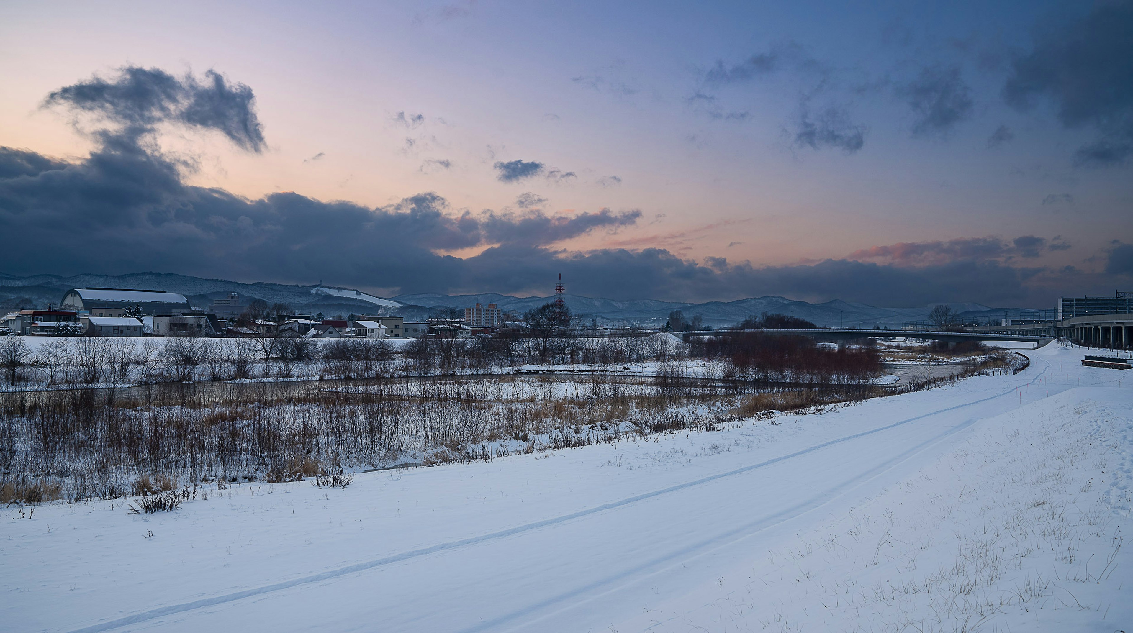 Paisaje cubierto de nieve con un cielo al atardecer