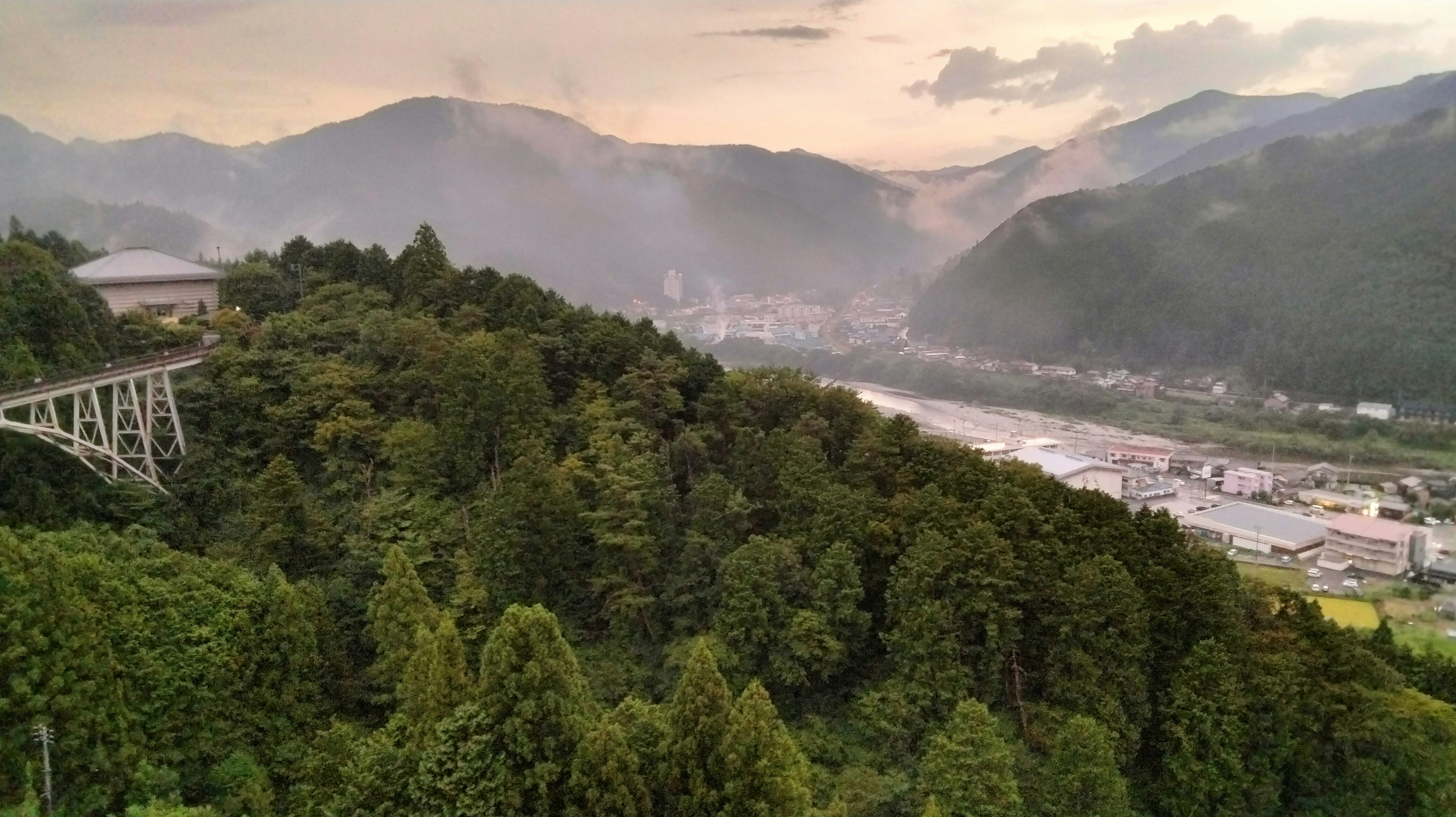 山々に囲まれた緑豊かな風景と川が見える