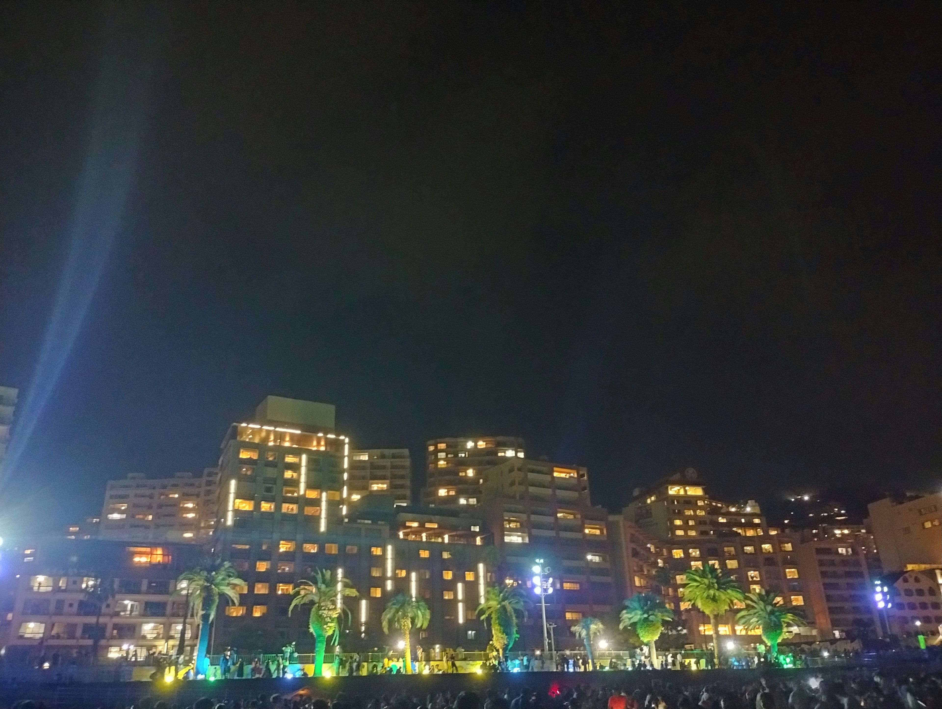 Paisaje urbano nocturno con edificios iluminados y luces verdes vibrantes