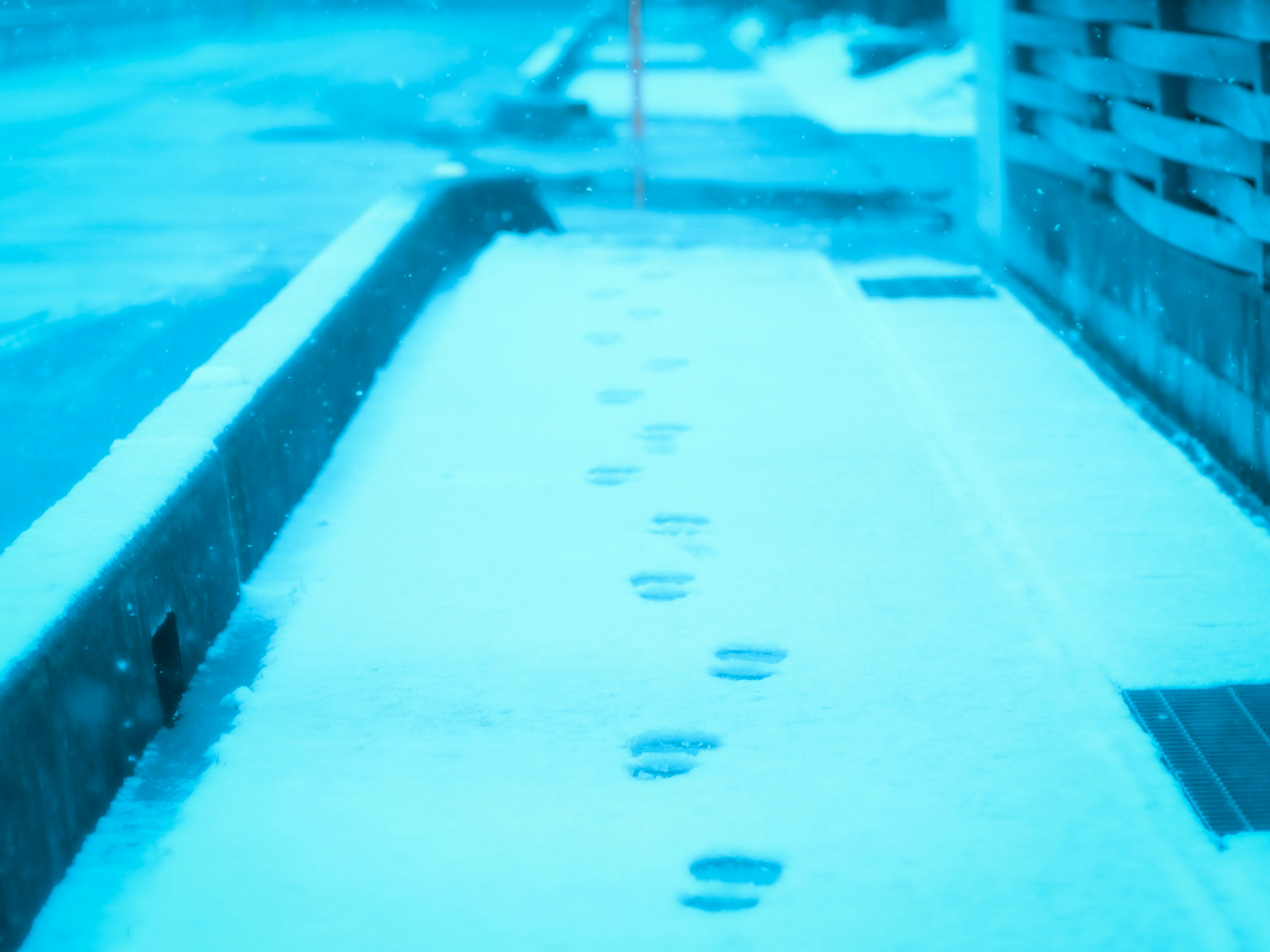 雪の上に残された足跡が続く静かな歩道の風景