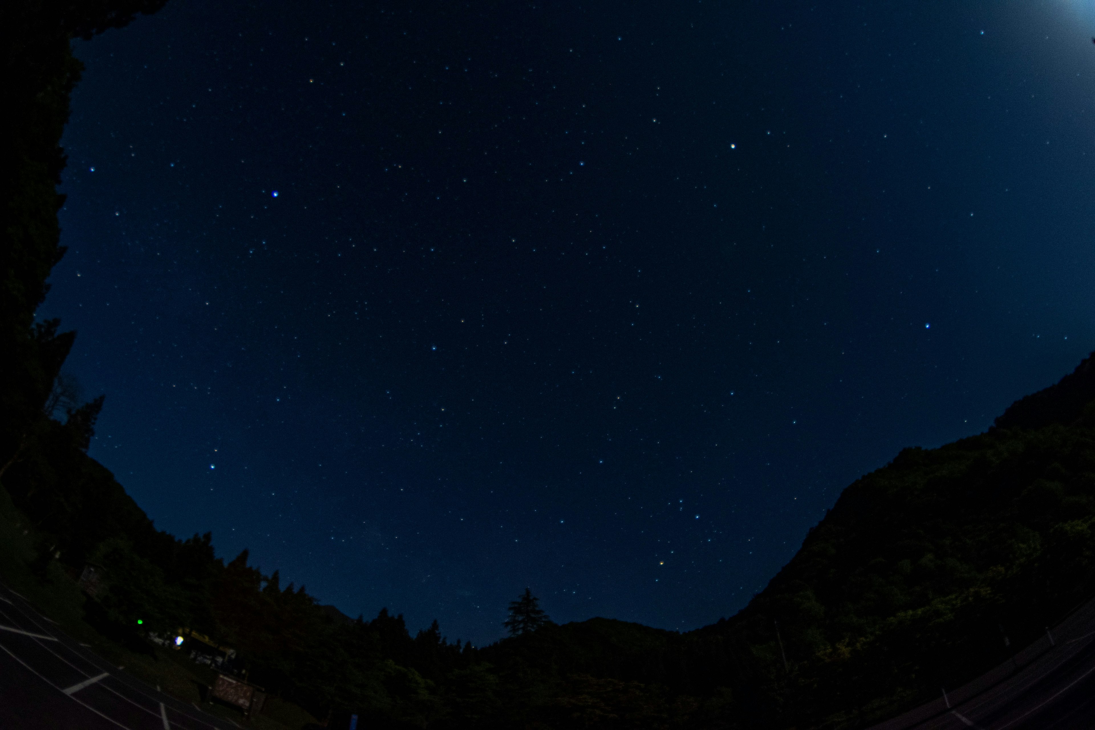 Night sky filled with stars and moonlight illuminating the landscape