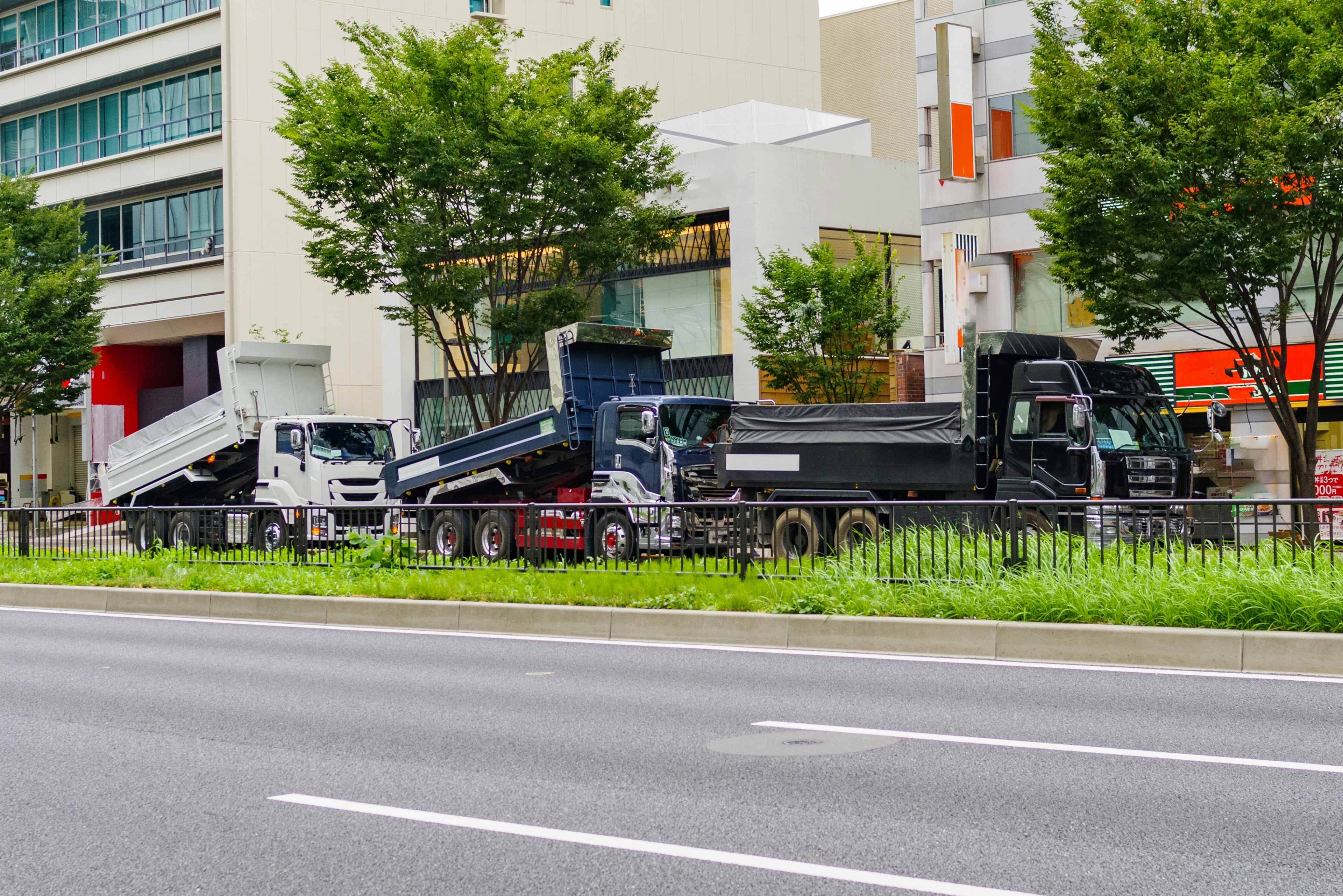 Groupe de camions garés le long d'une route avec des bâtiments à proximité