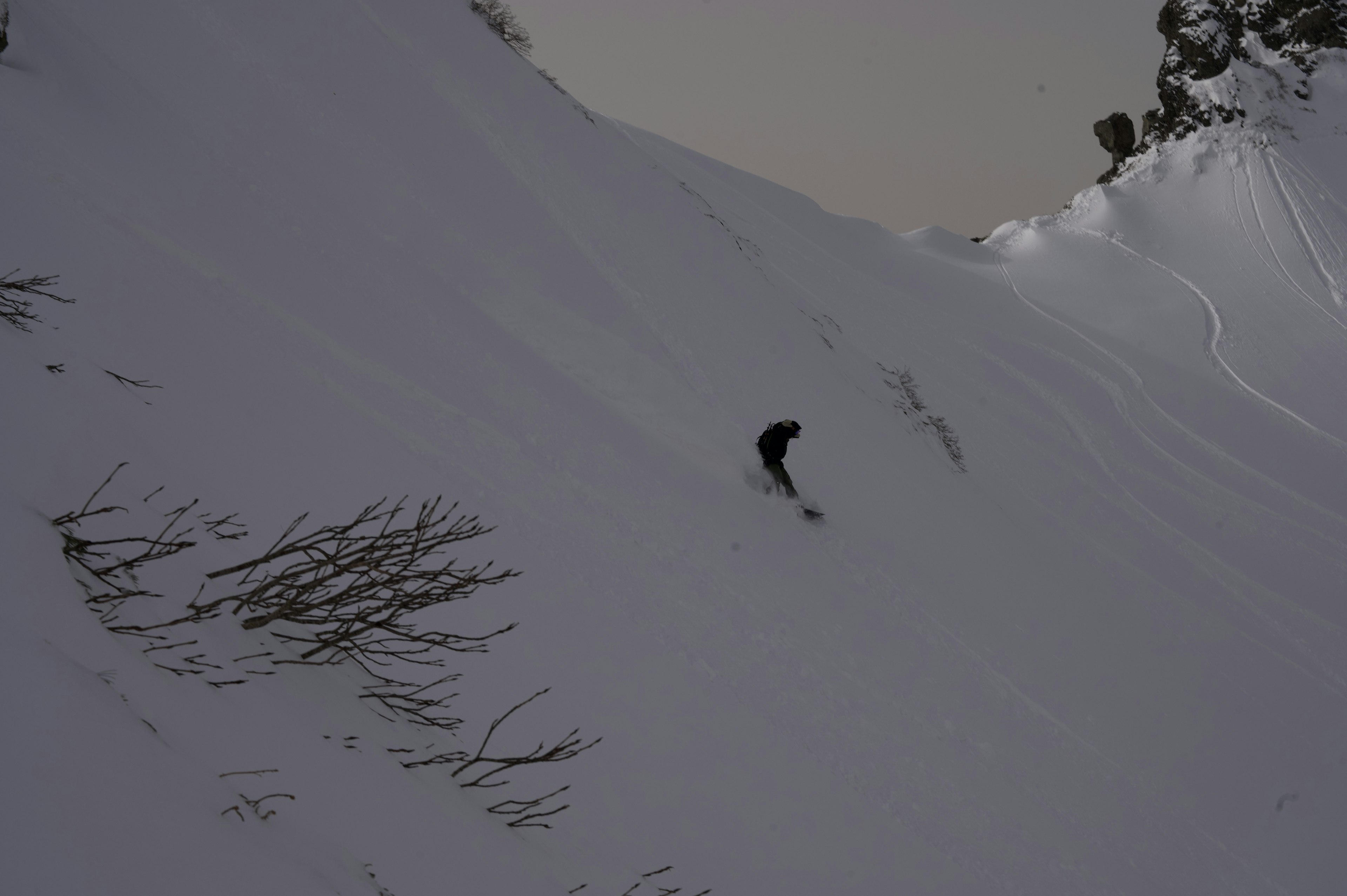 Silhouette einer Person, die auf einem verschneiten Berg snowboardet