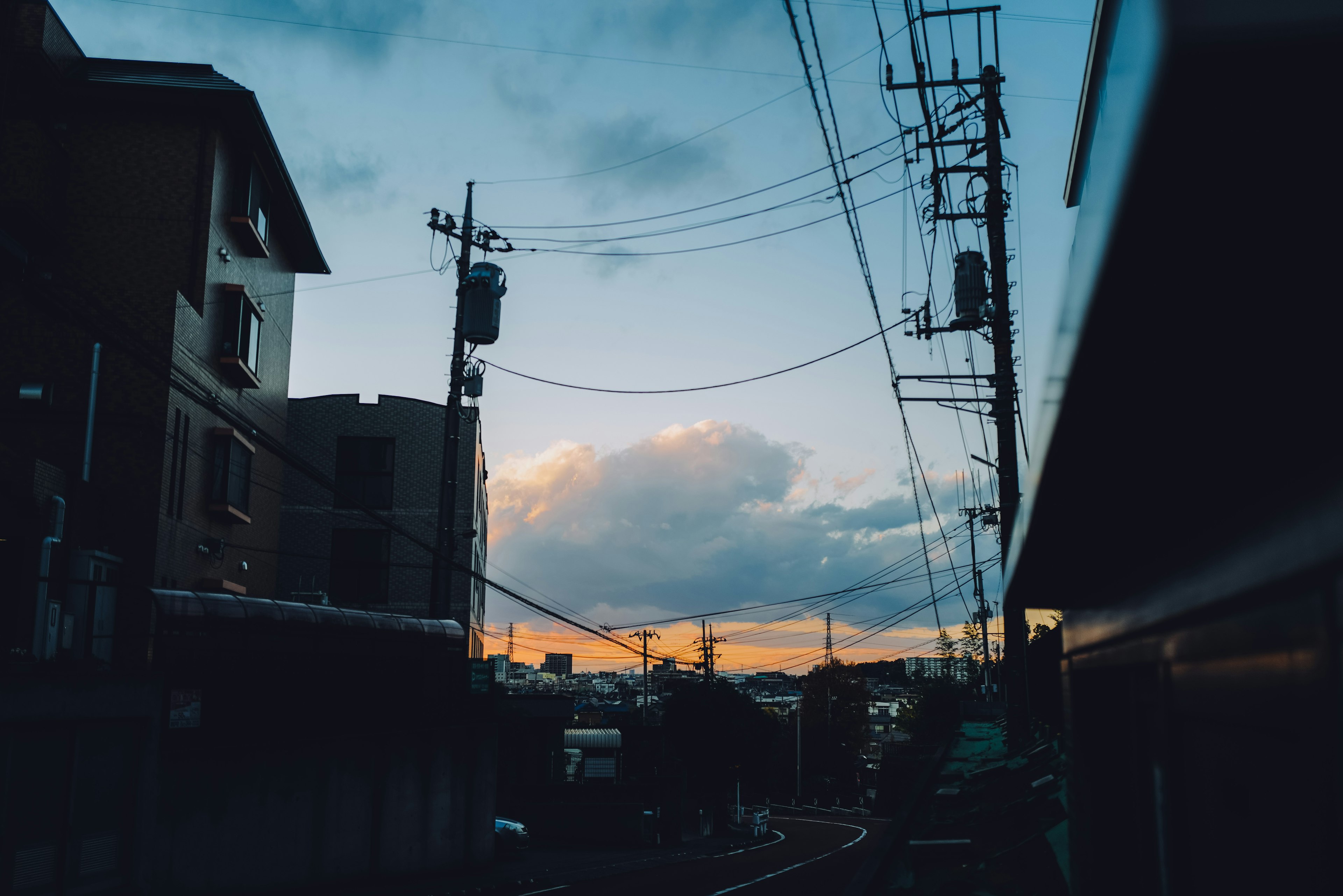 夕焼けの空と電線が見える都市の風景