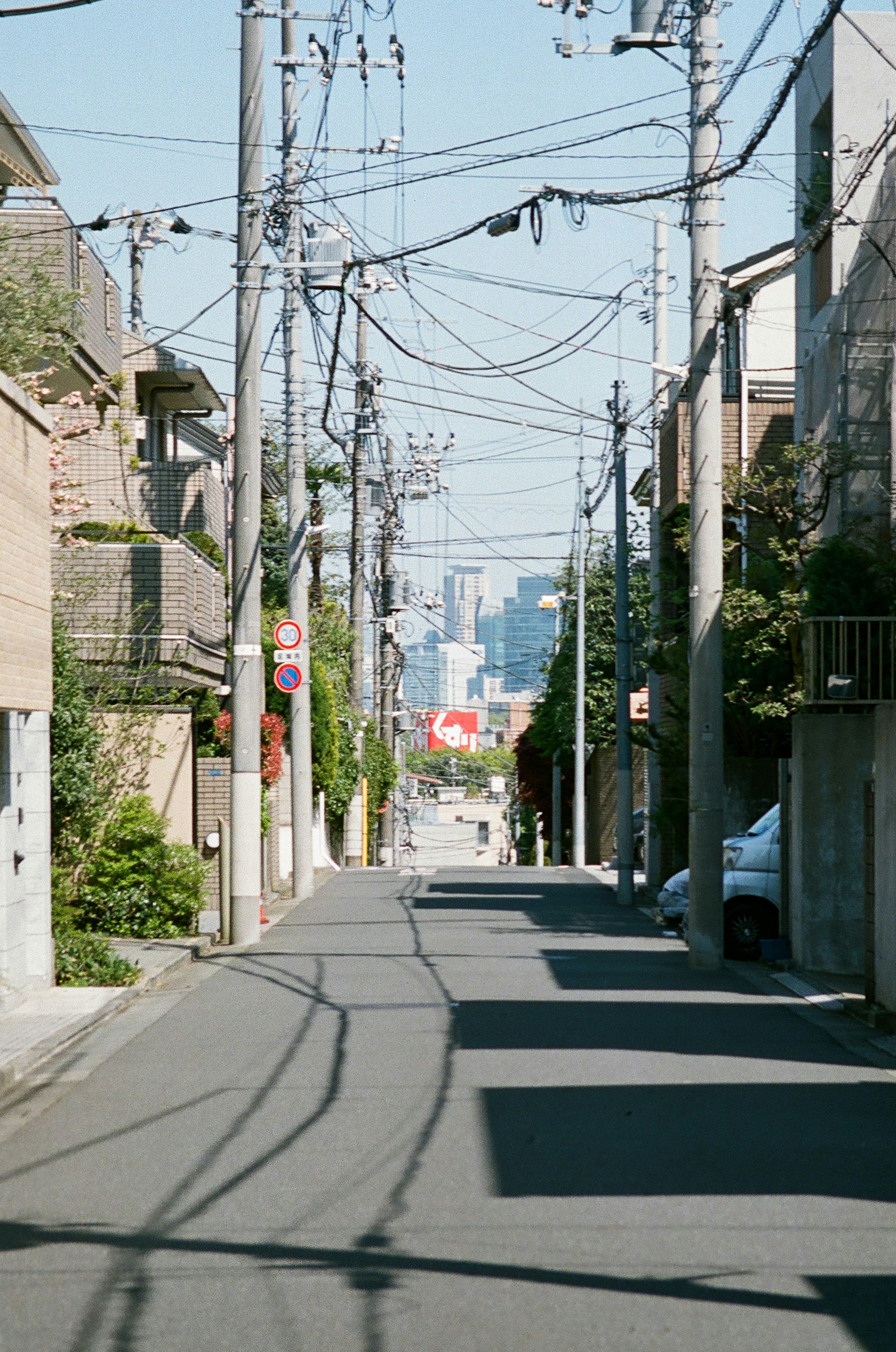 Callejón estrecho con casas y líneas eléctricas