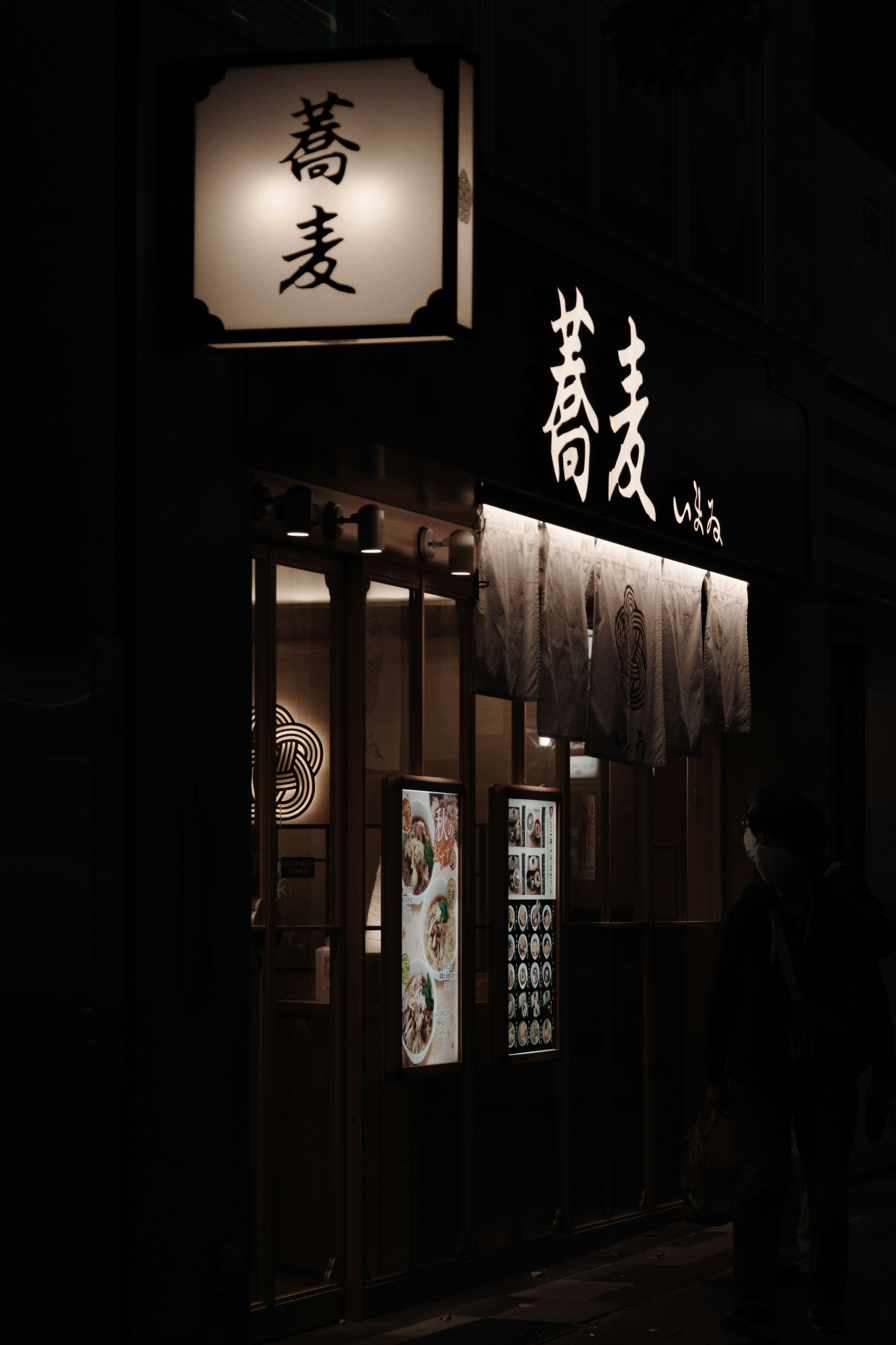 Außenansicht eines Soba-Restaurants in einer dunklen Straße mit einem Schild mit dem Wort Soba