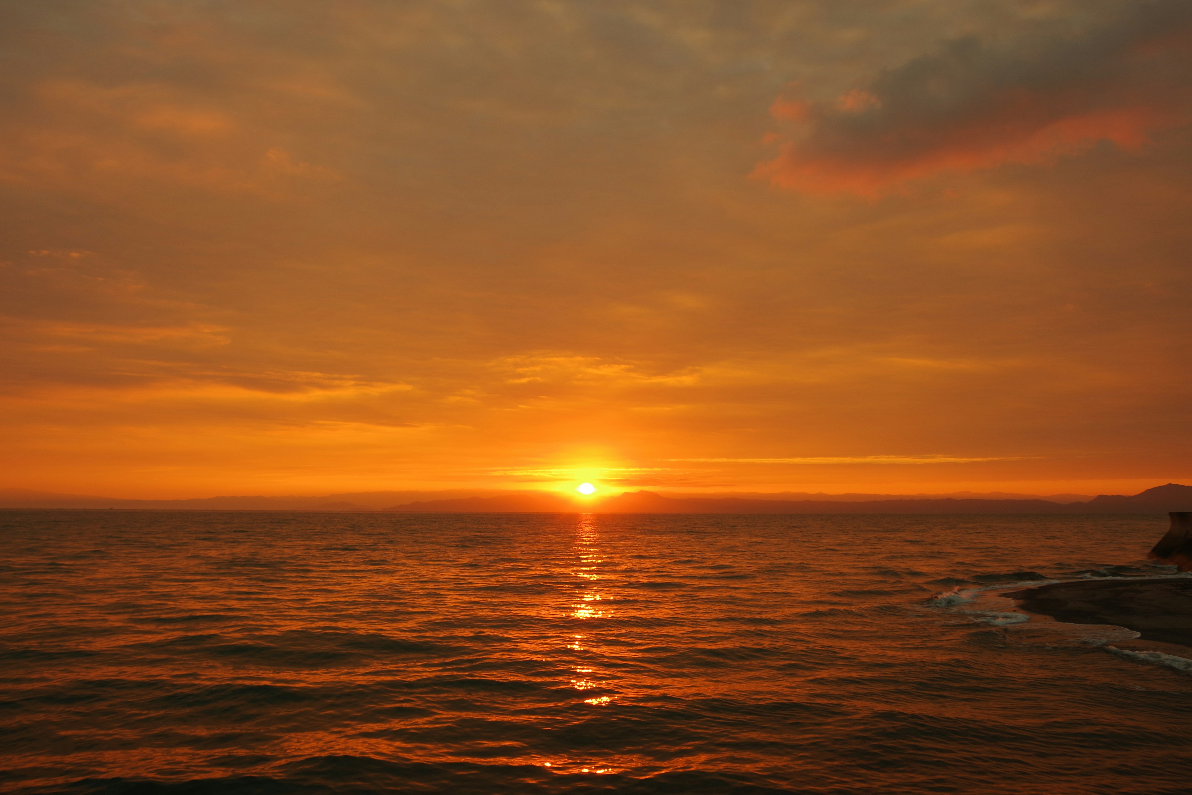 Magnifique paysage maritime avec coucher de soleil ciel orange et reflets sur les vagues