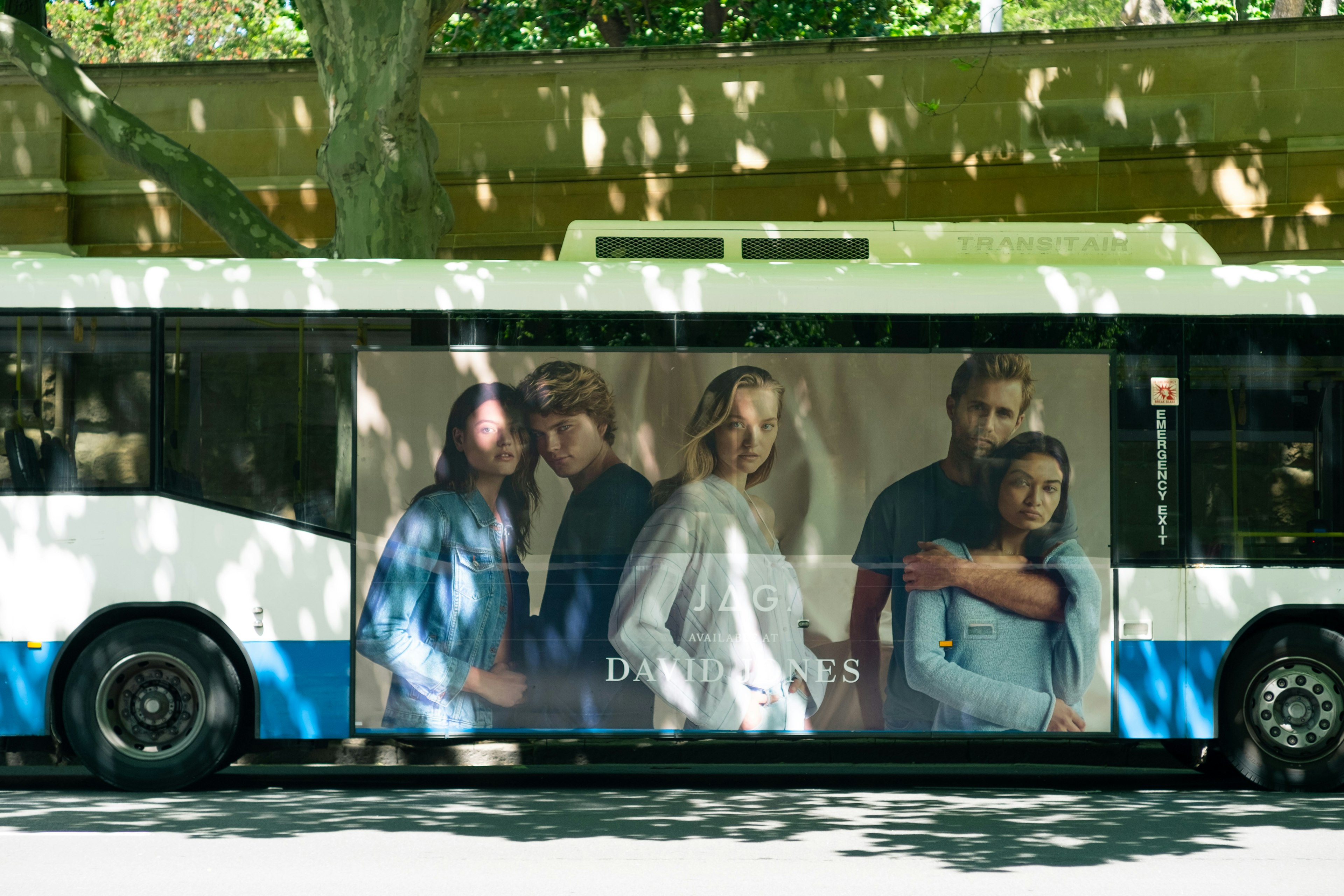 A bus featuring an advertisement with four people posing together