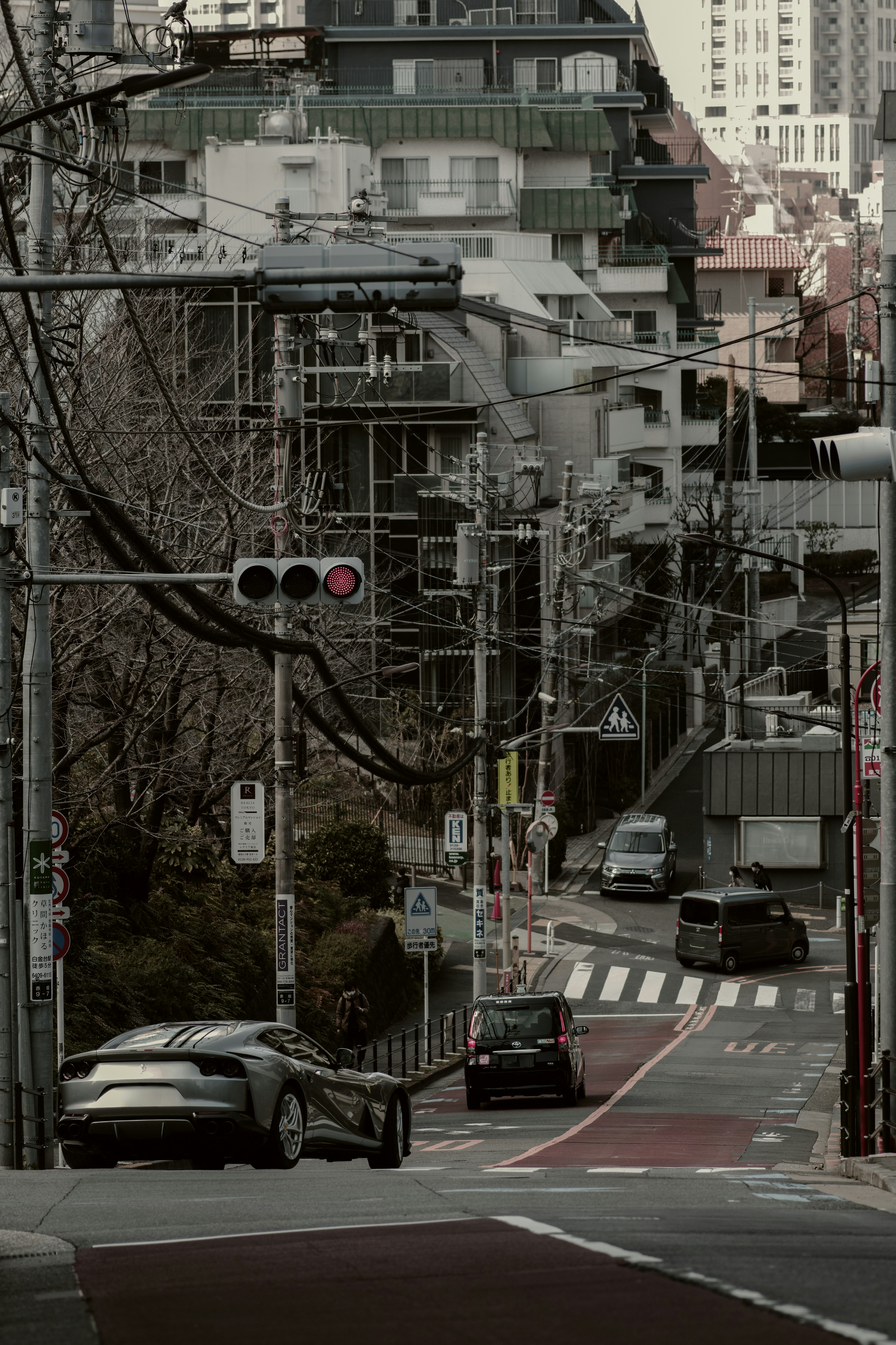 城市景观，斜坡街道上的汽车，交通信号灯，正在建设的建筑，电线