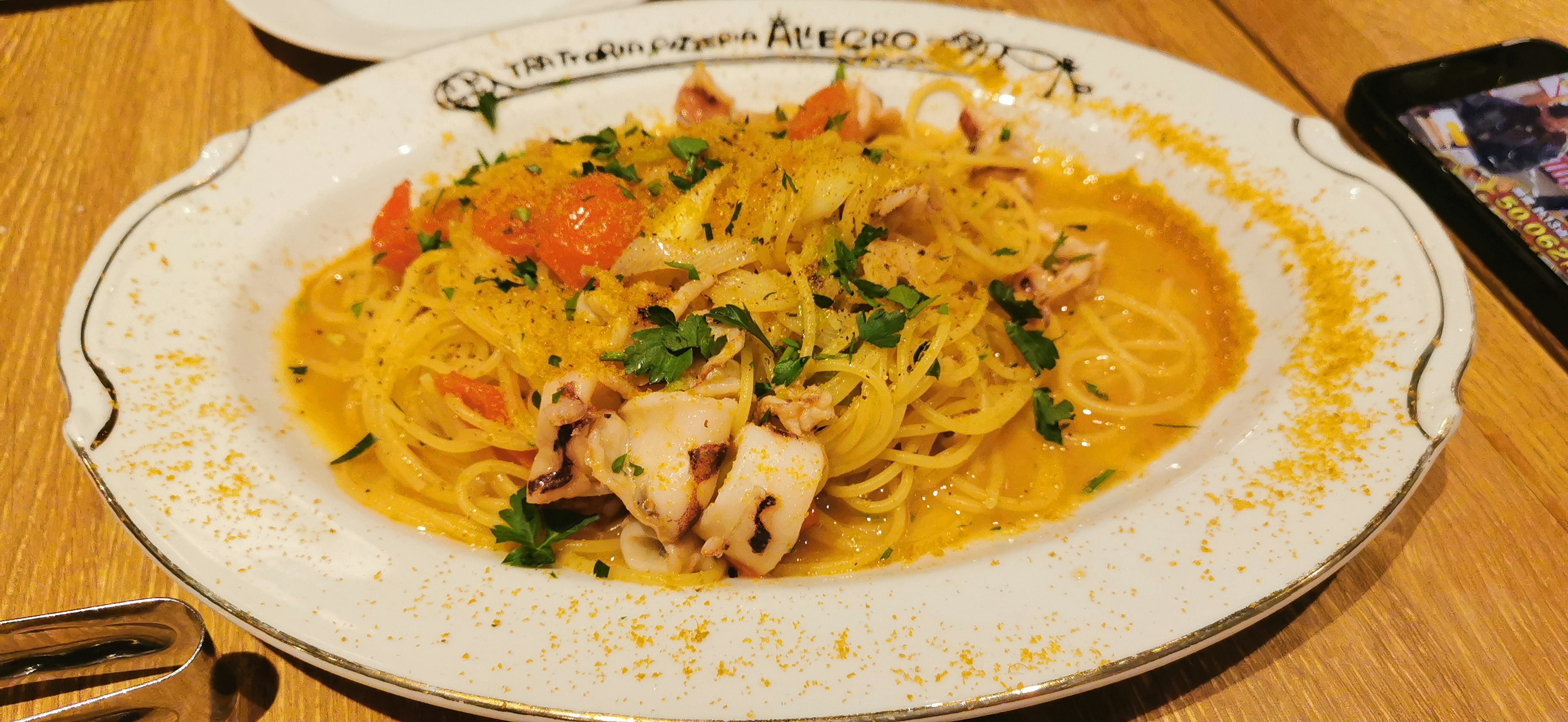 Delizioso piatto di pasta servito su un piatto bianco con pomodori e prezzemolo