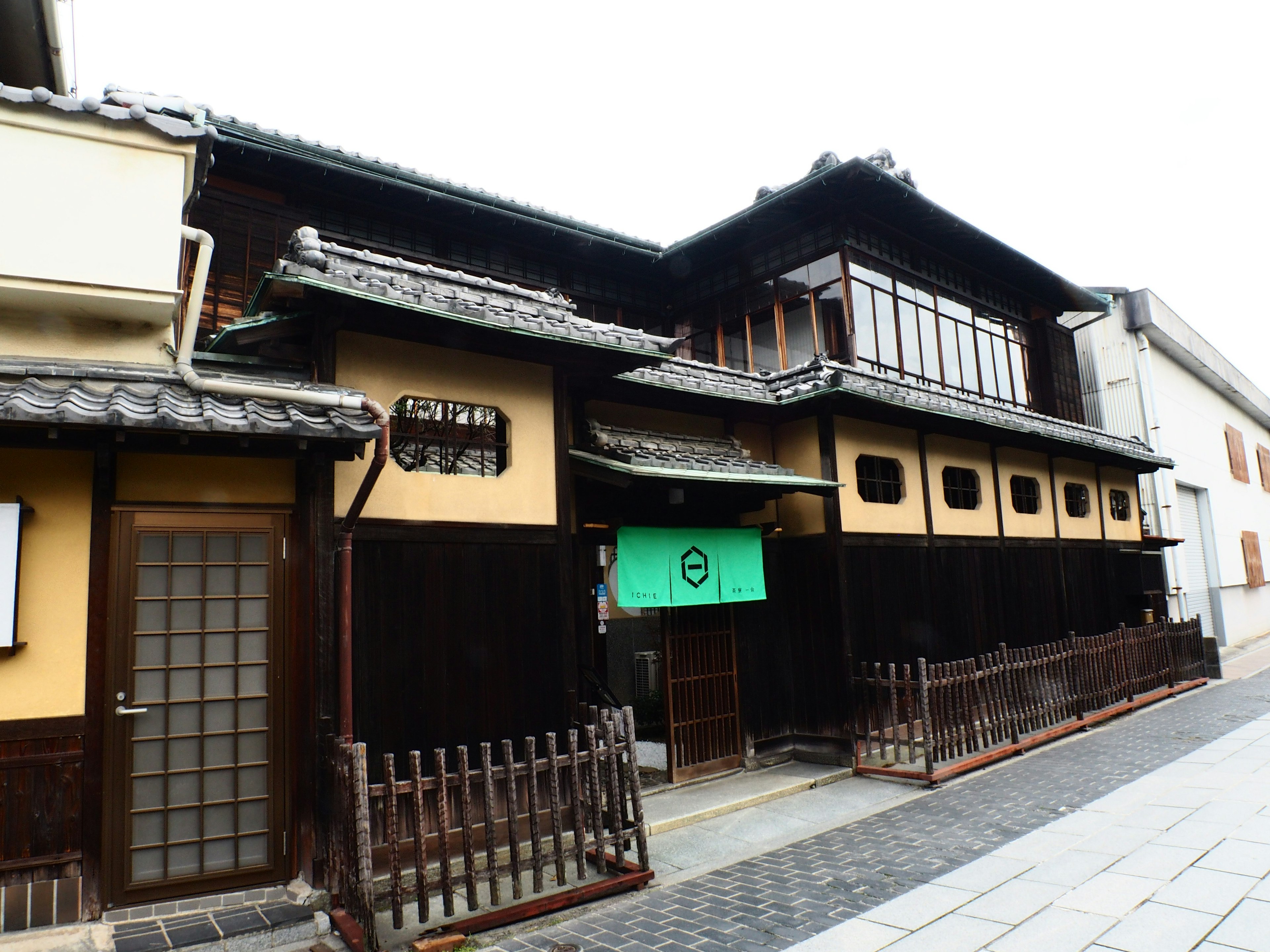 Traditionelle japanische Architektur mit schwarzem Holzausbau und grünem Norenvorhang