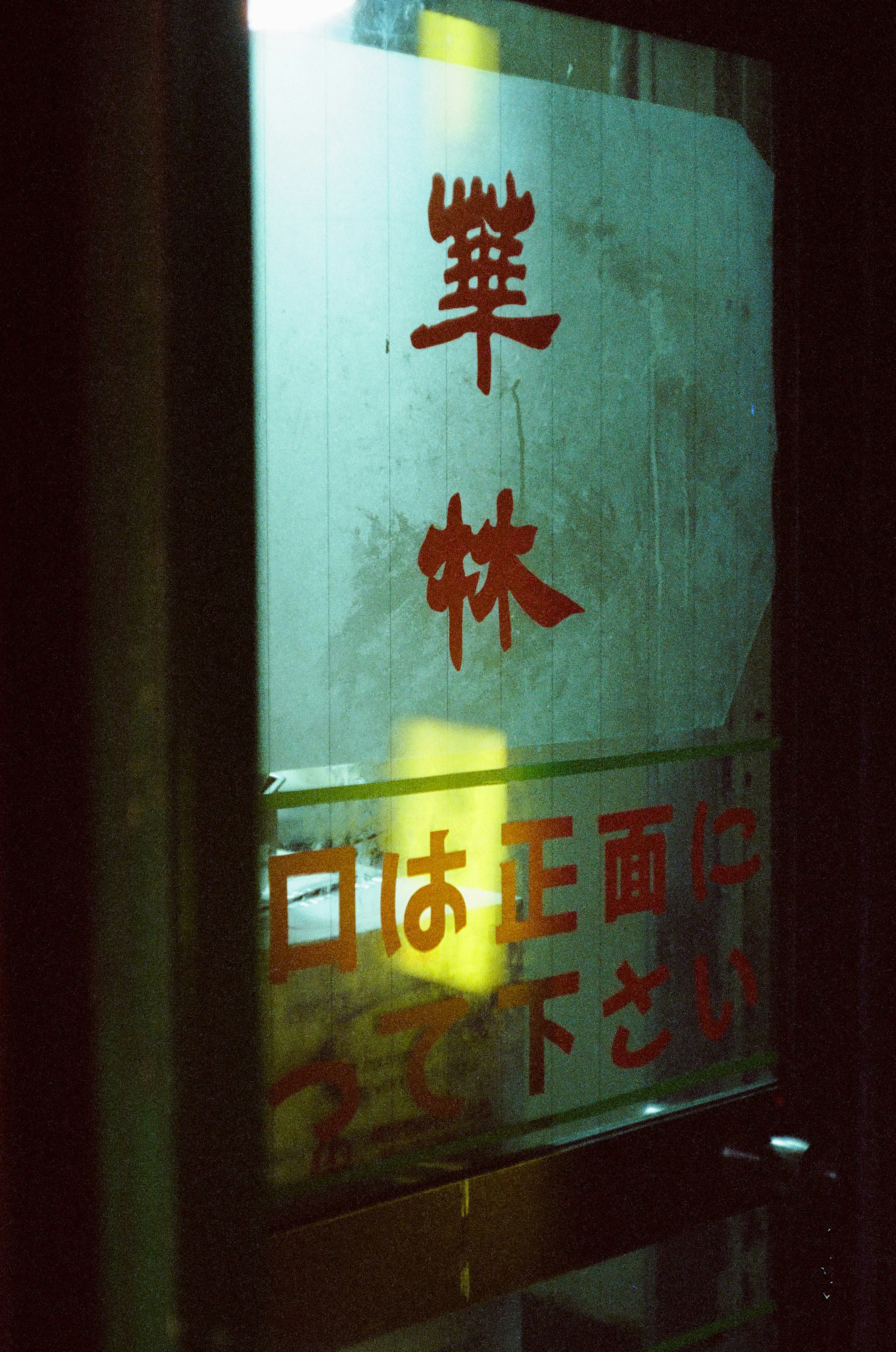 Una puerta de vidrio con un letrero de texto rojo