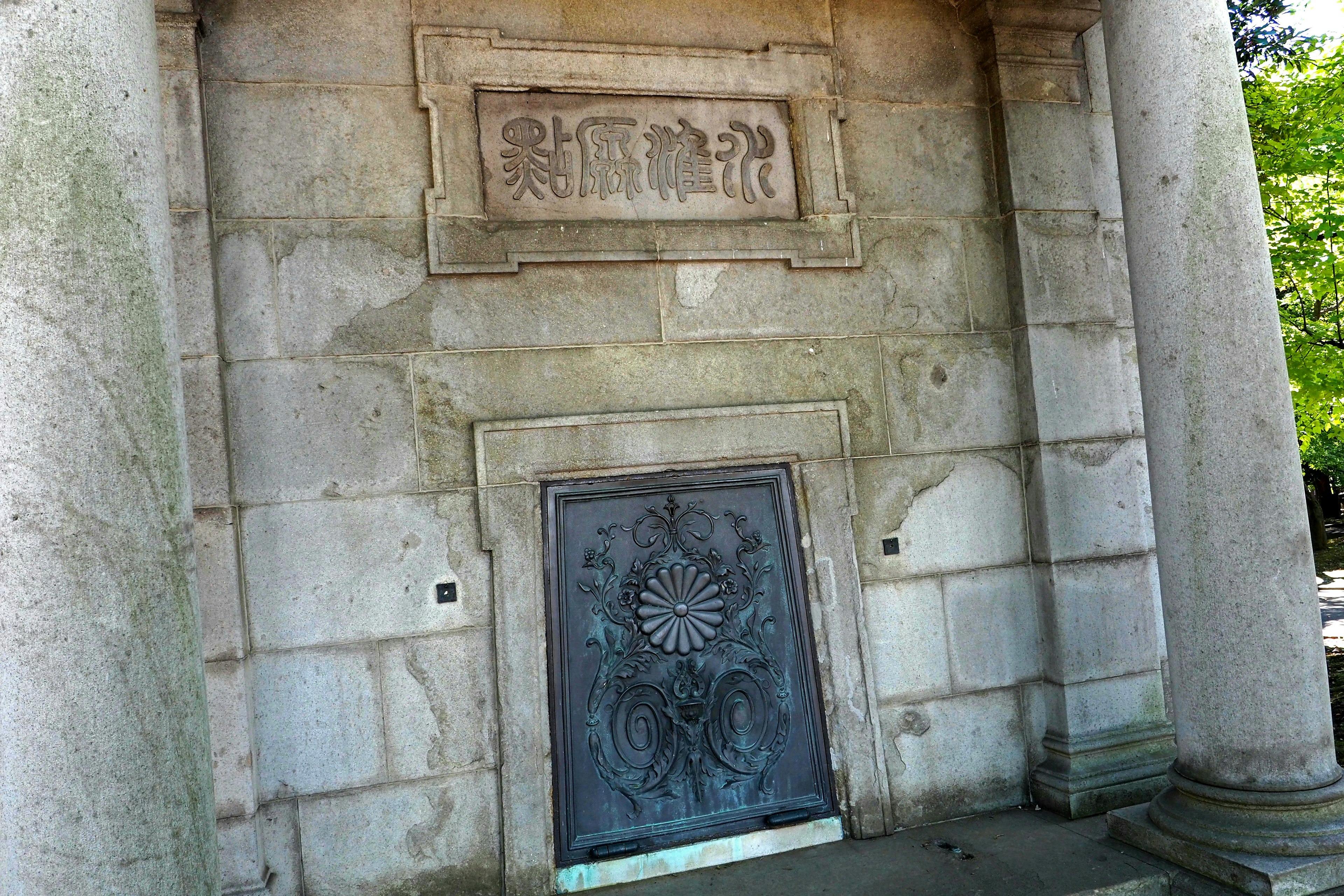 Entrada de una antigua estructura de piedra con una puerta decorada y esculturas