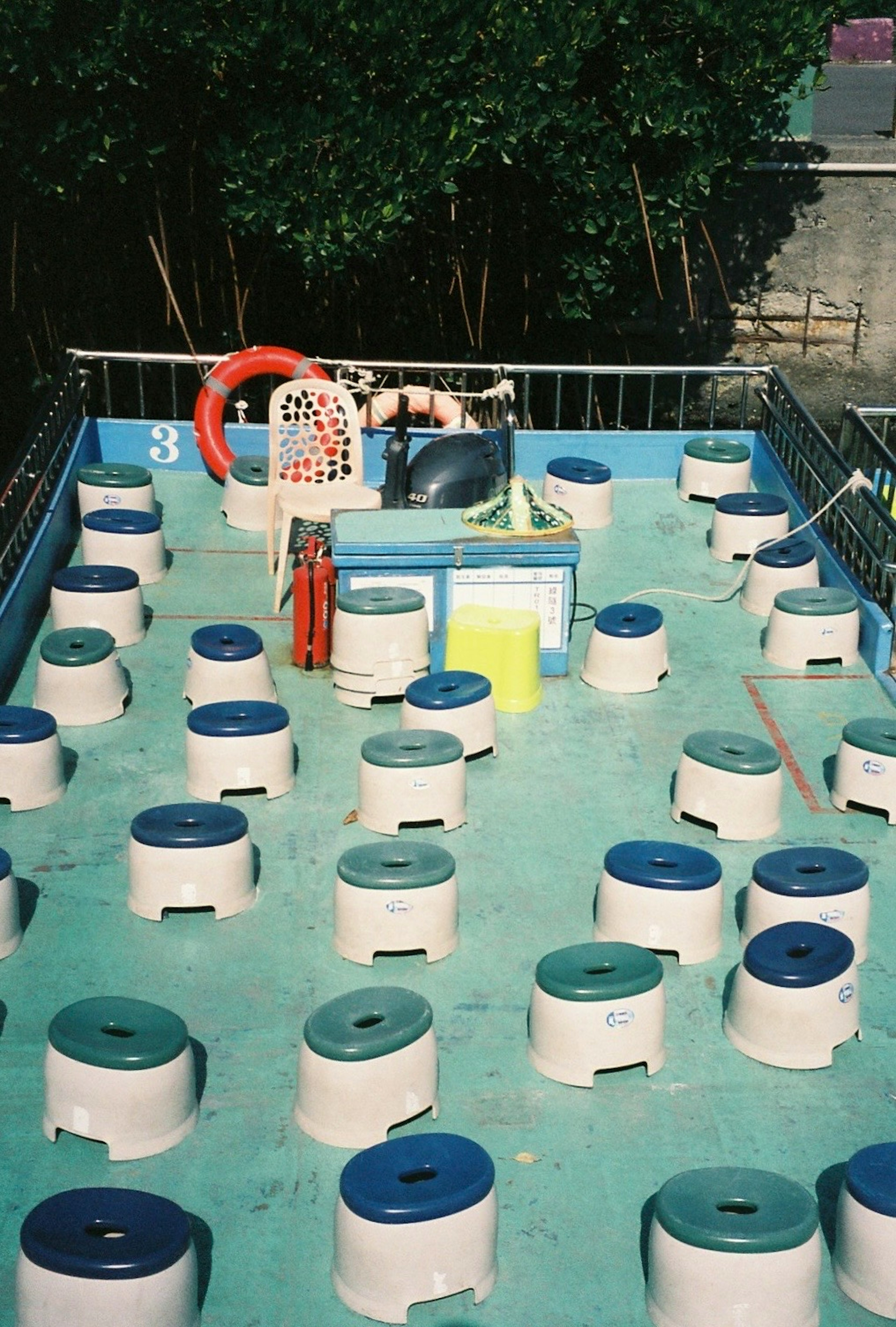 Play area with white buckets and blue lids arranged in a water play zone