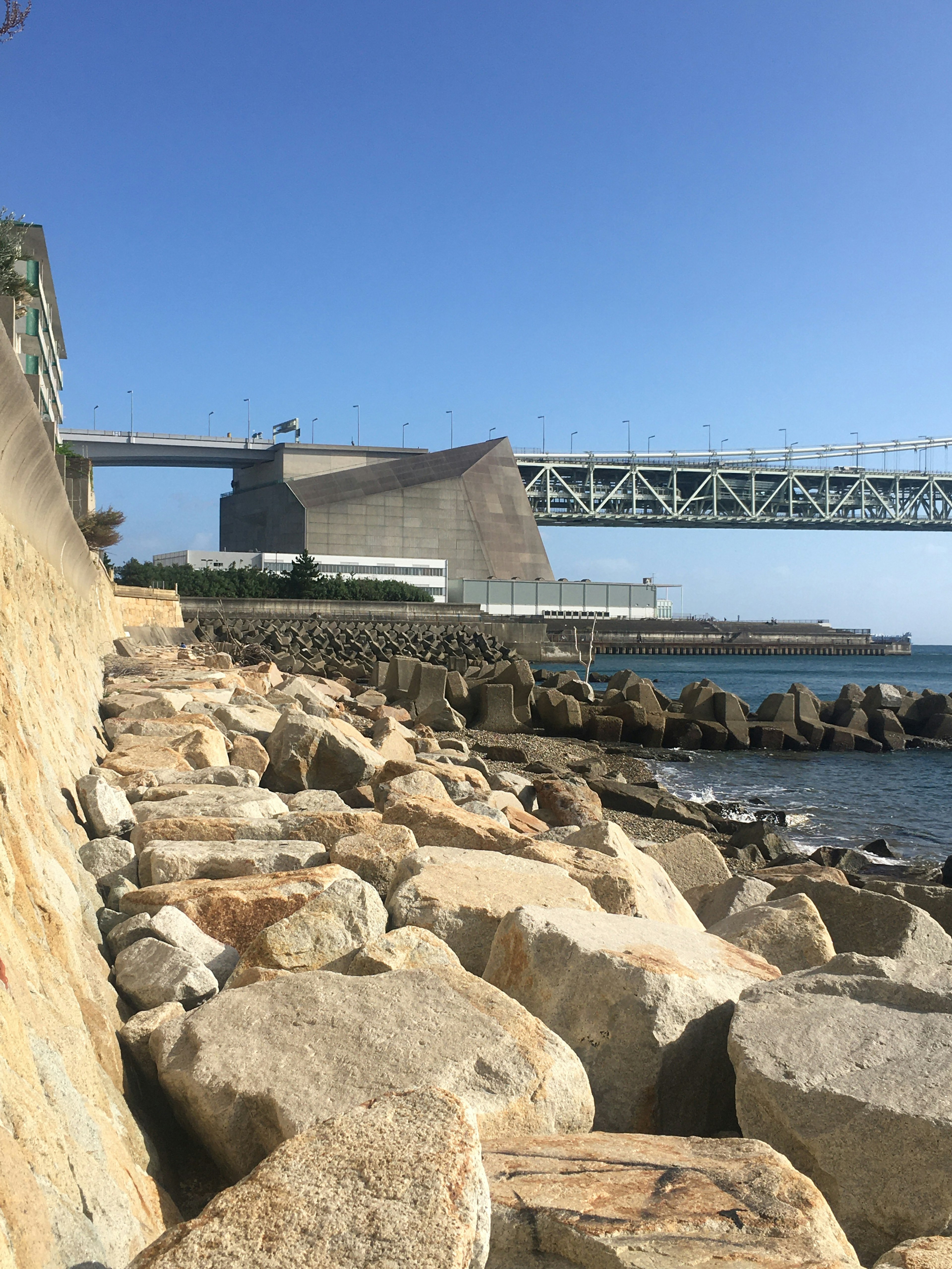 海岸の岩と近代的な建物の景色 橋が見える