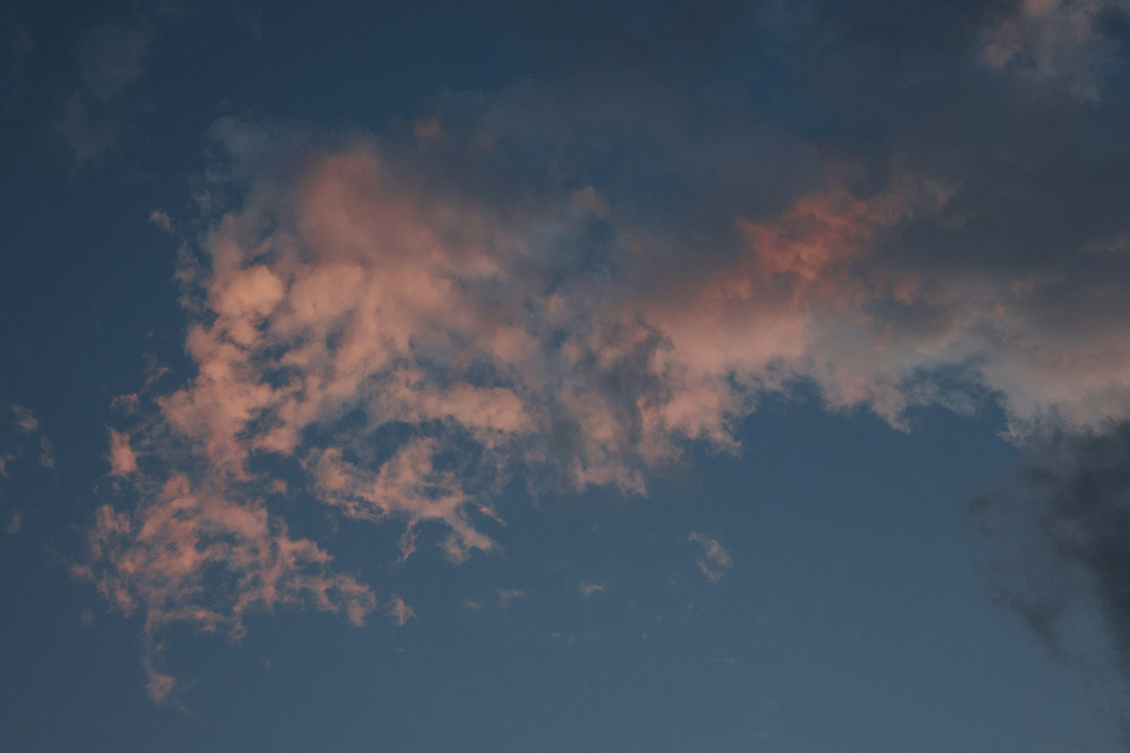 A beautiful scene with orange clouds floating in a blue sky