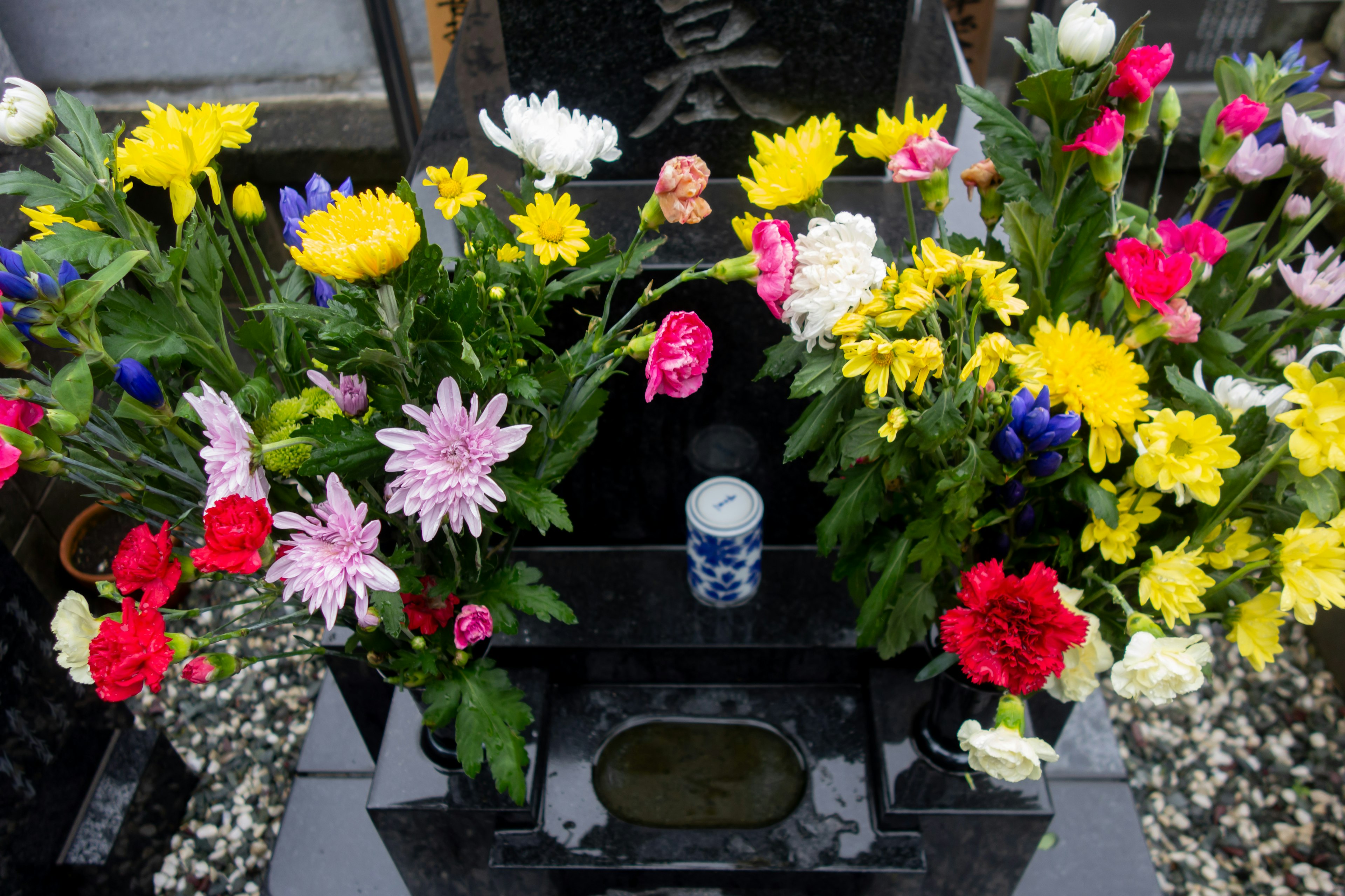 Eine lebhafte Anordnung von Blumen an einem Grabstein