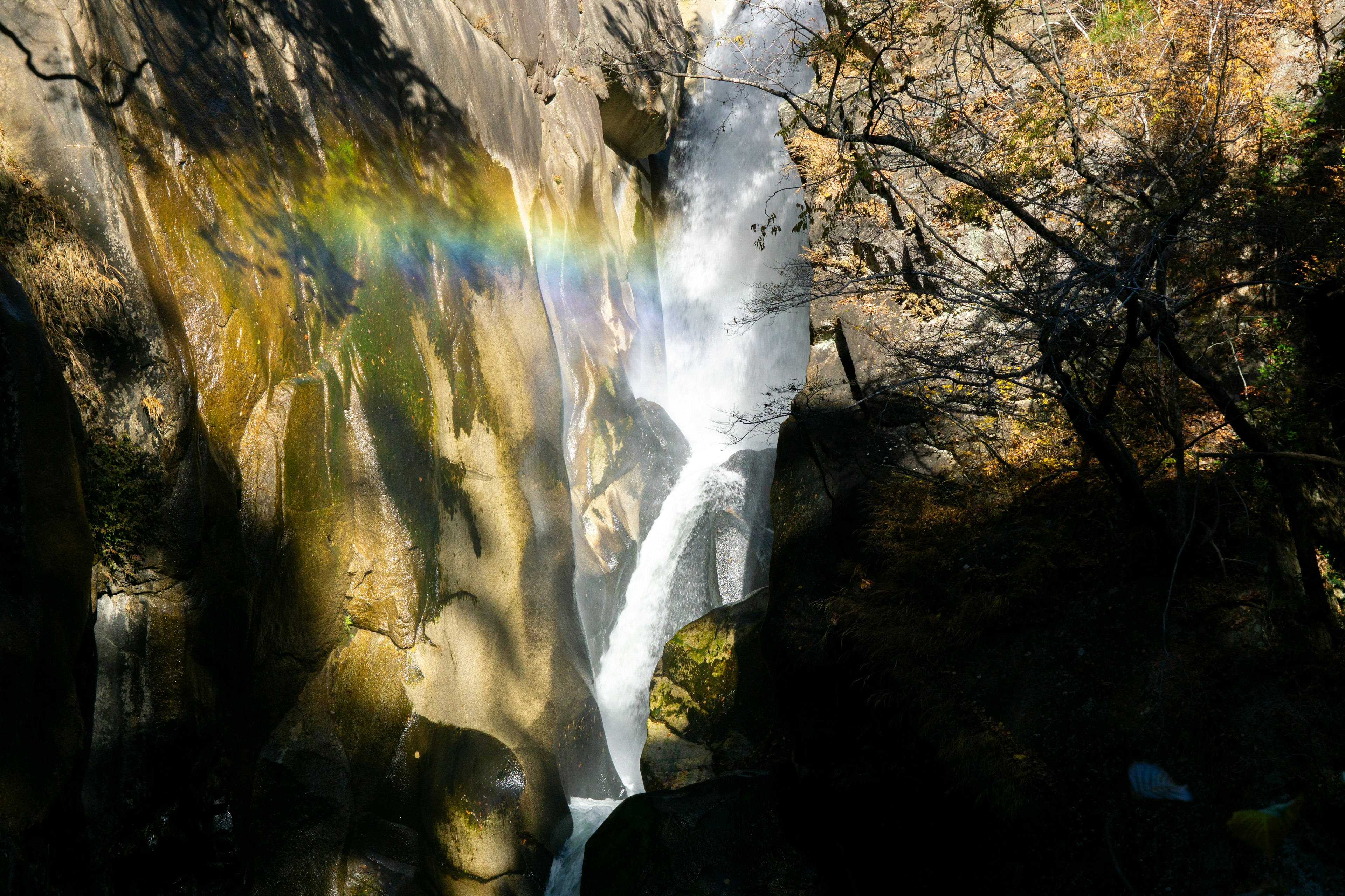 Bellissimo paesaggio con una cascata, nebbia e un arcobaleno