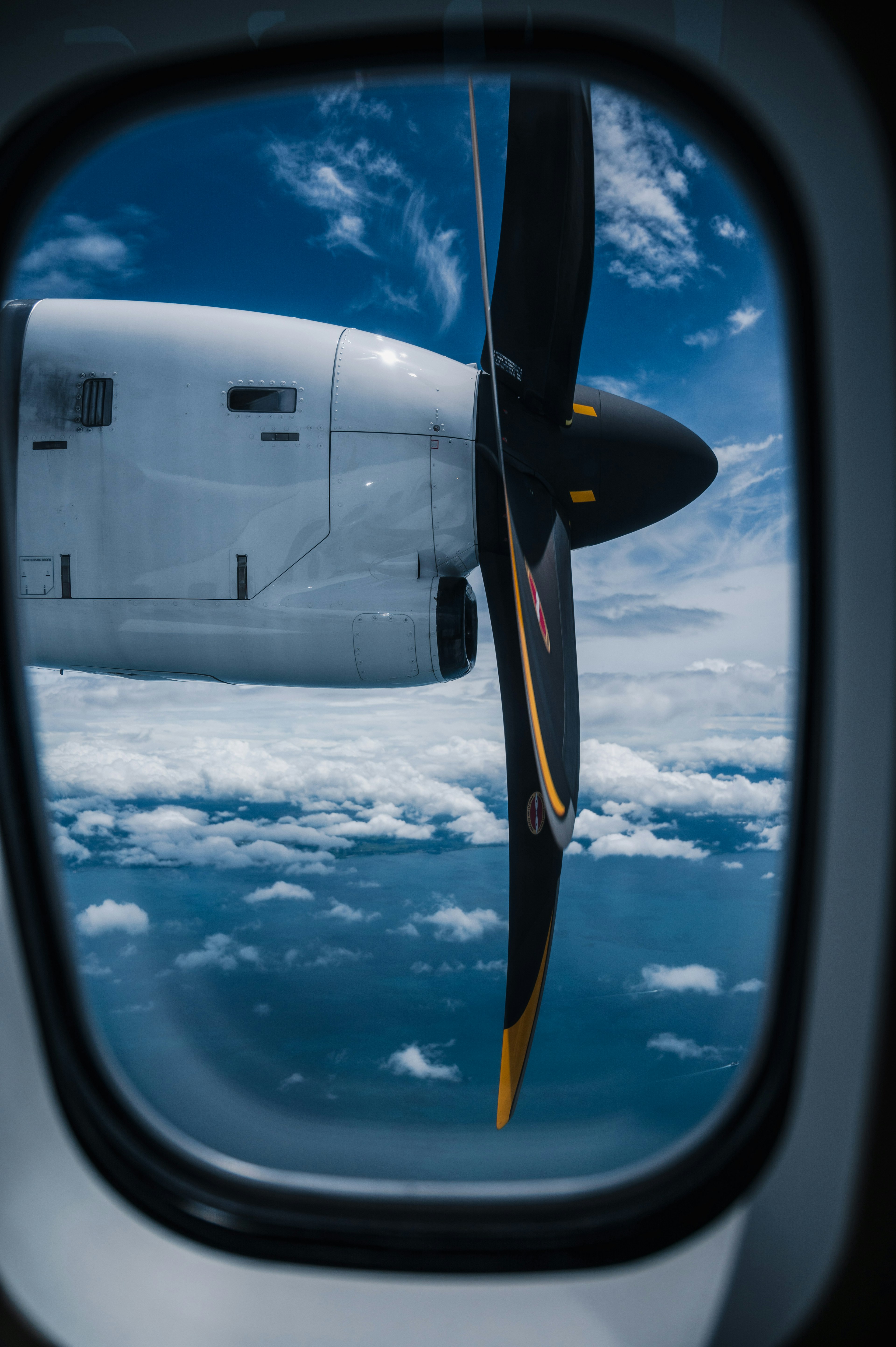 Elica di aereo visibile attraverso la finestra con cielo blu