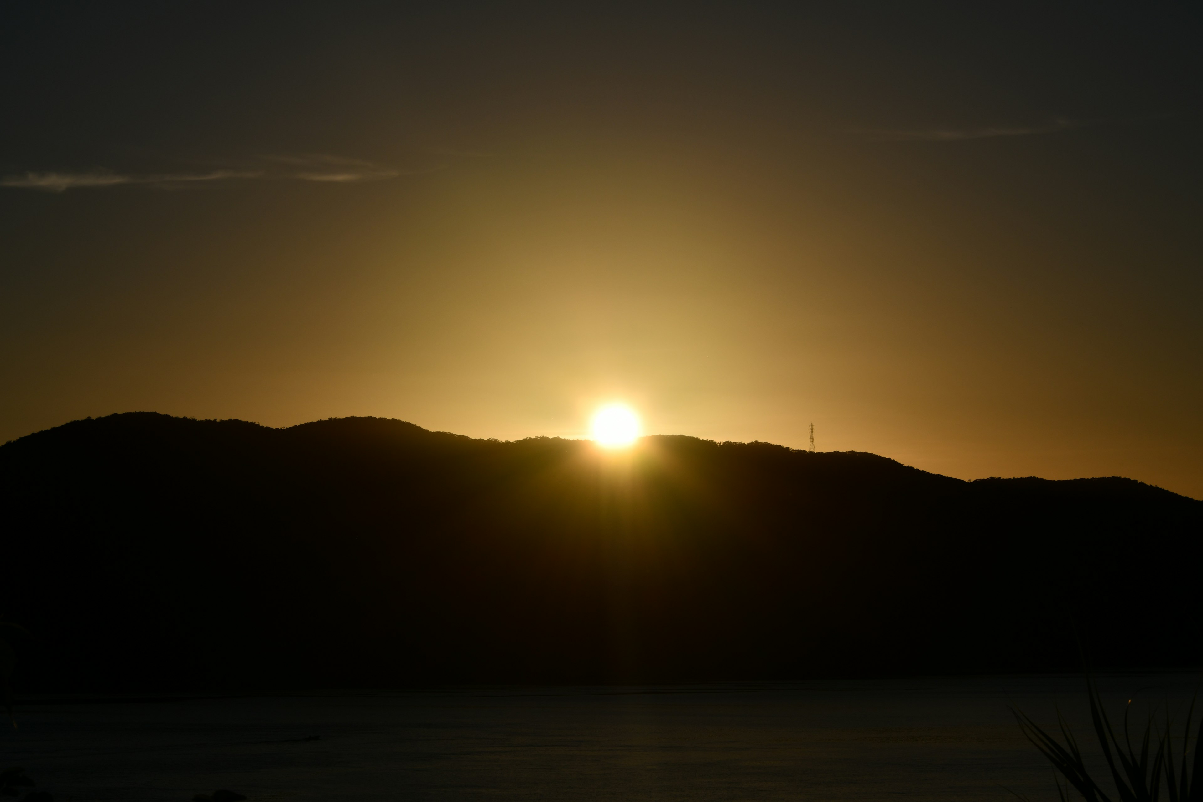 Silhouette der Sonne, die hinter den Bergen aufgeht