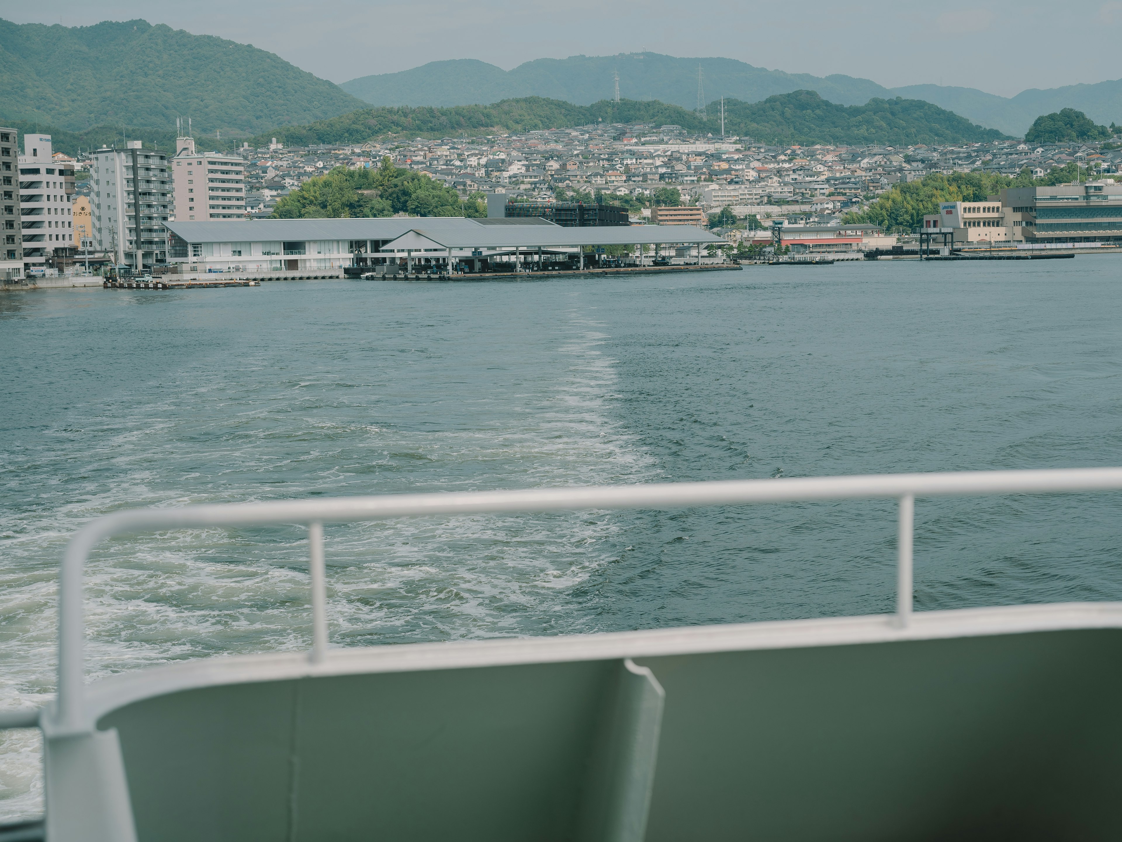 Vista desde un barco que muestra agua y montañas distantes